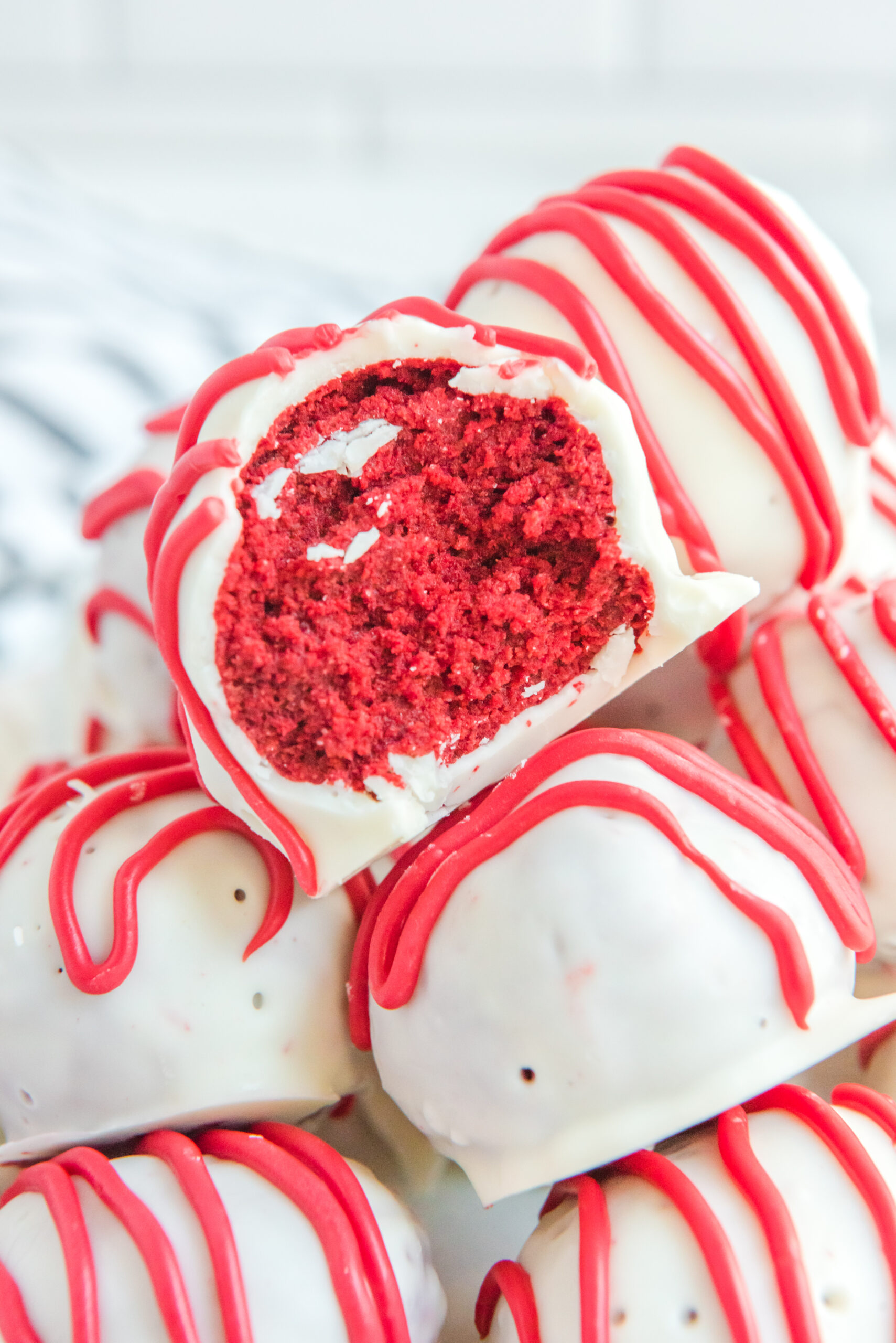 Close up of a bite removed from a red velvet cake ball.