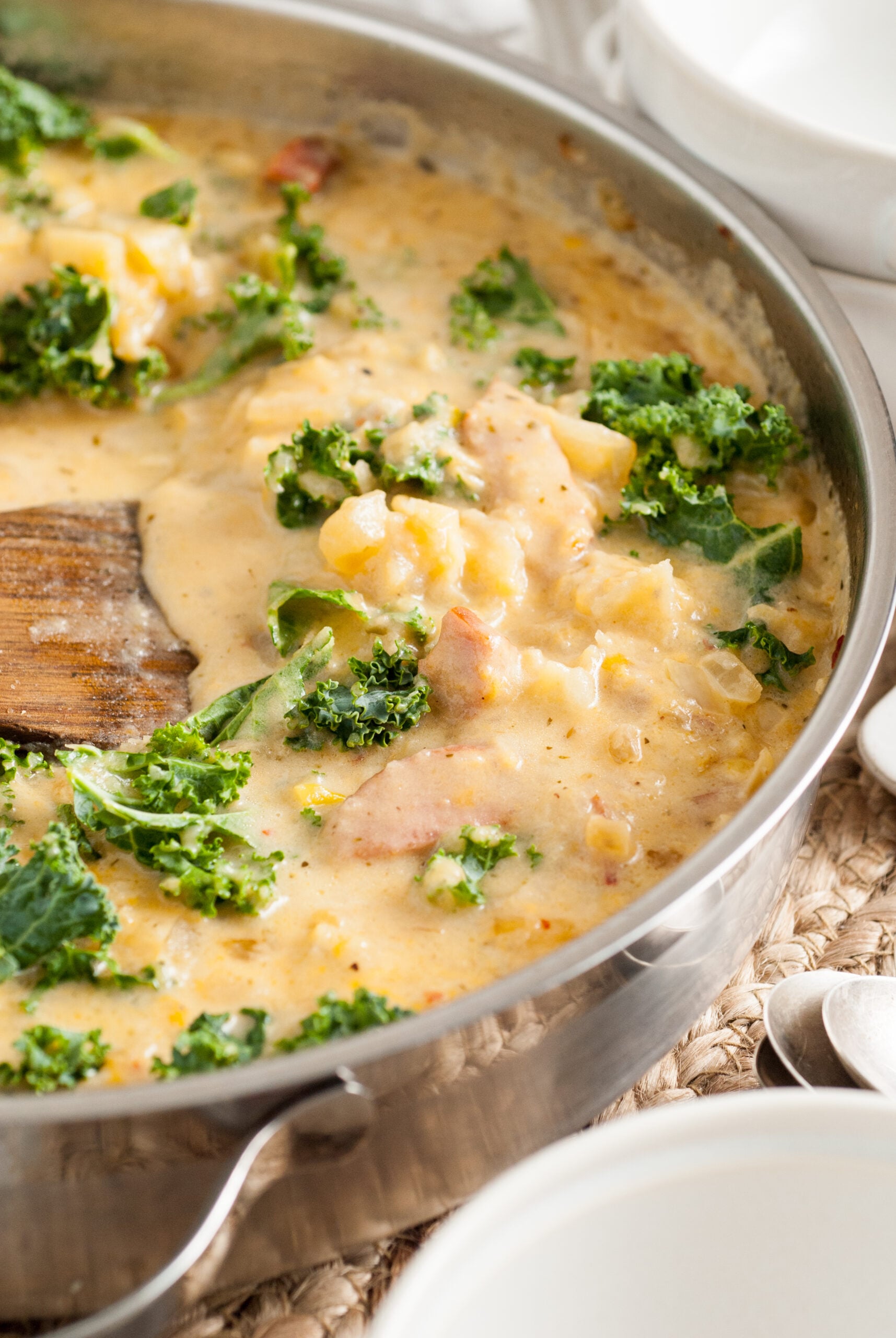 Side shot of Kielbasa Potato soup in a silver skillet. 