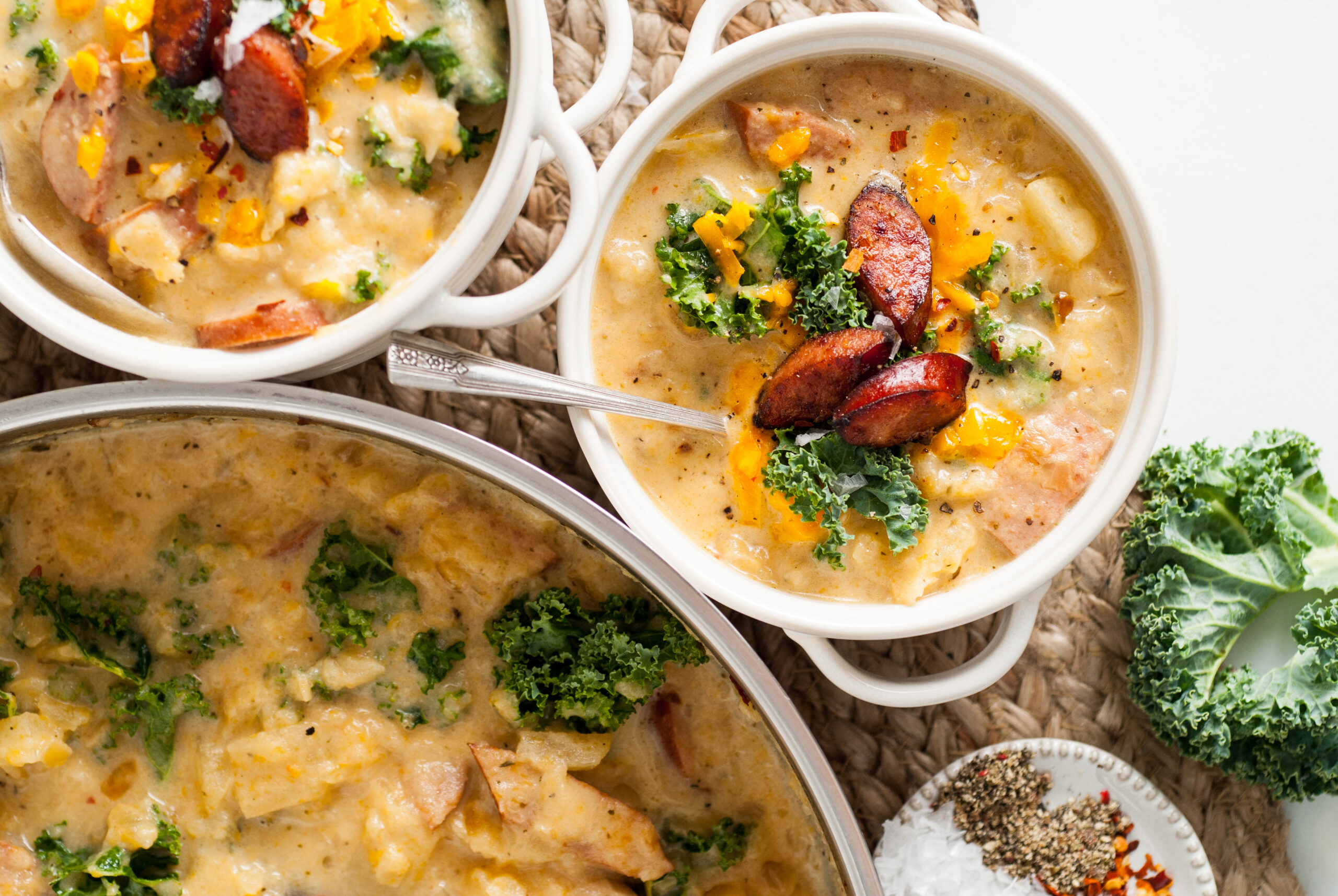 Overhead shot of the soup in two white bowls topped with Kale and cooked Kielbasa. 