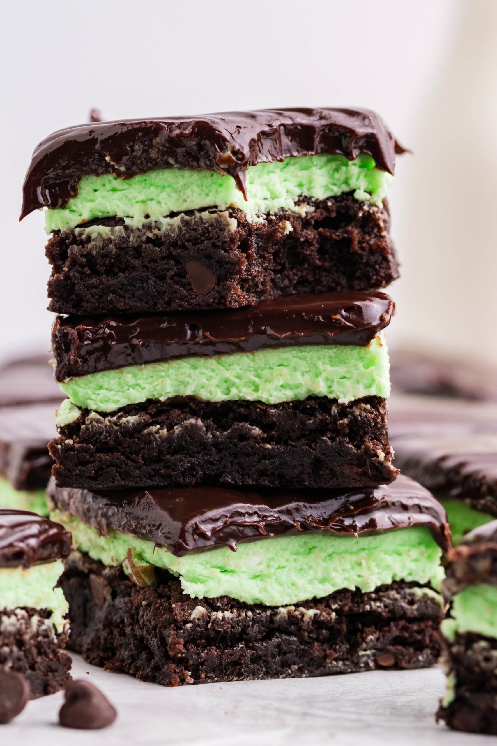 Three brownies stacked on top of each other with a bite removed from the top brownie.