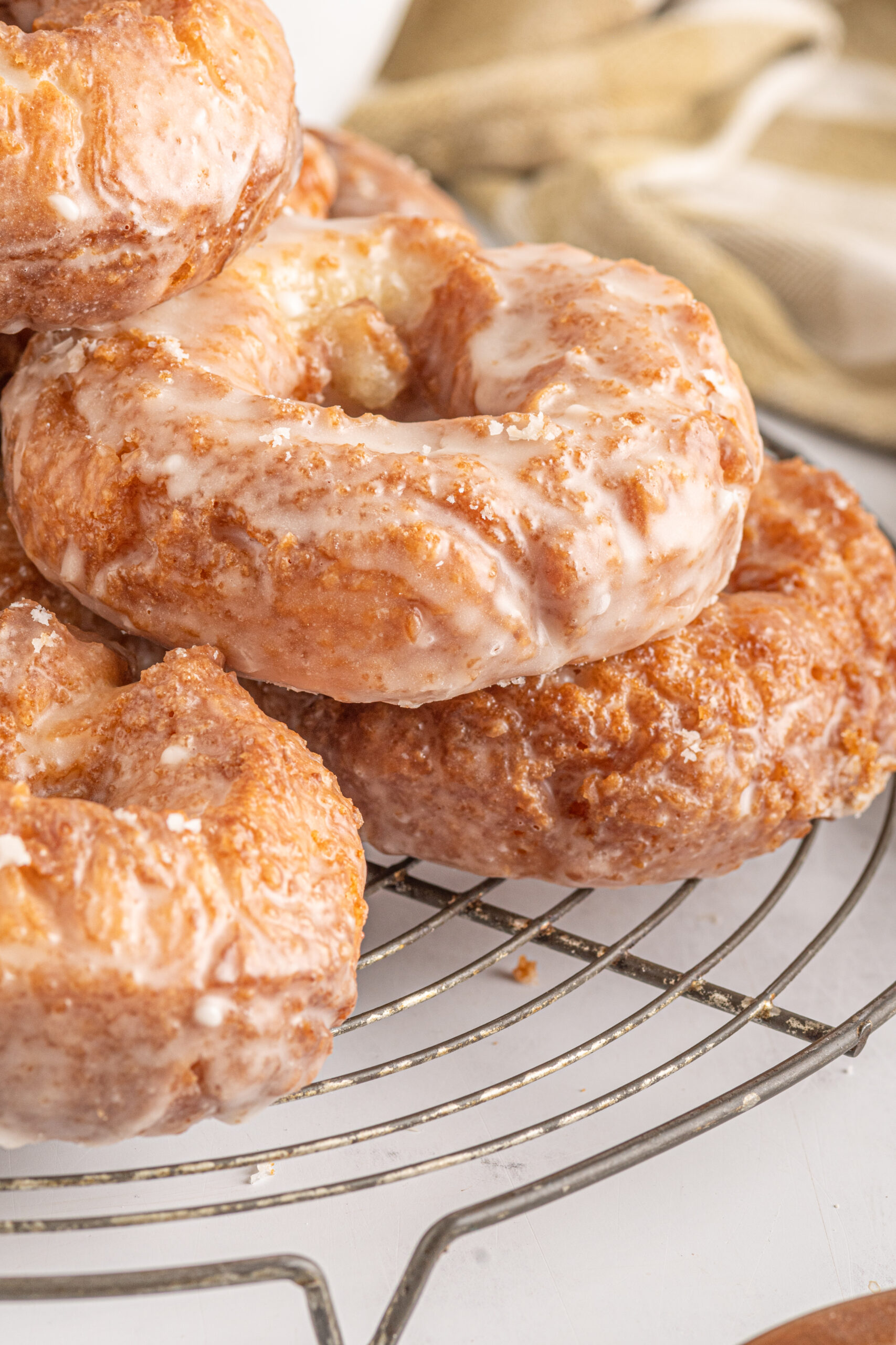 Side view of the donuts stacked on a wire cooling rack.