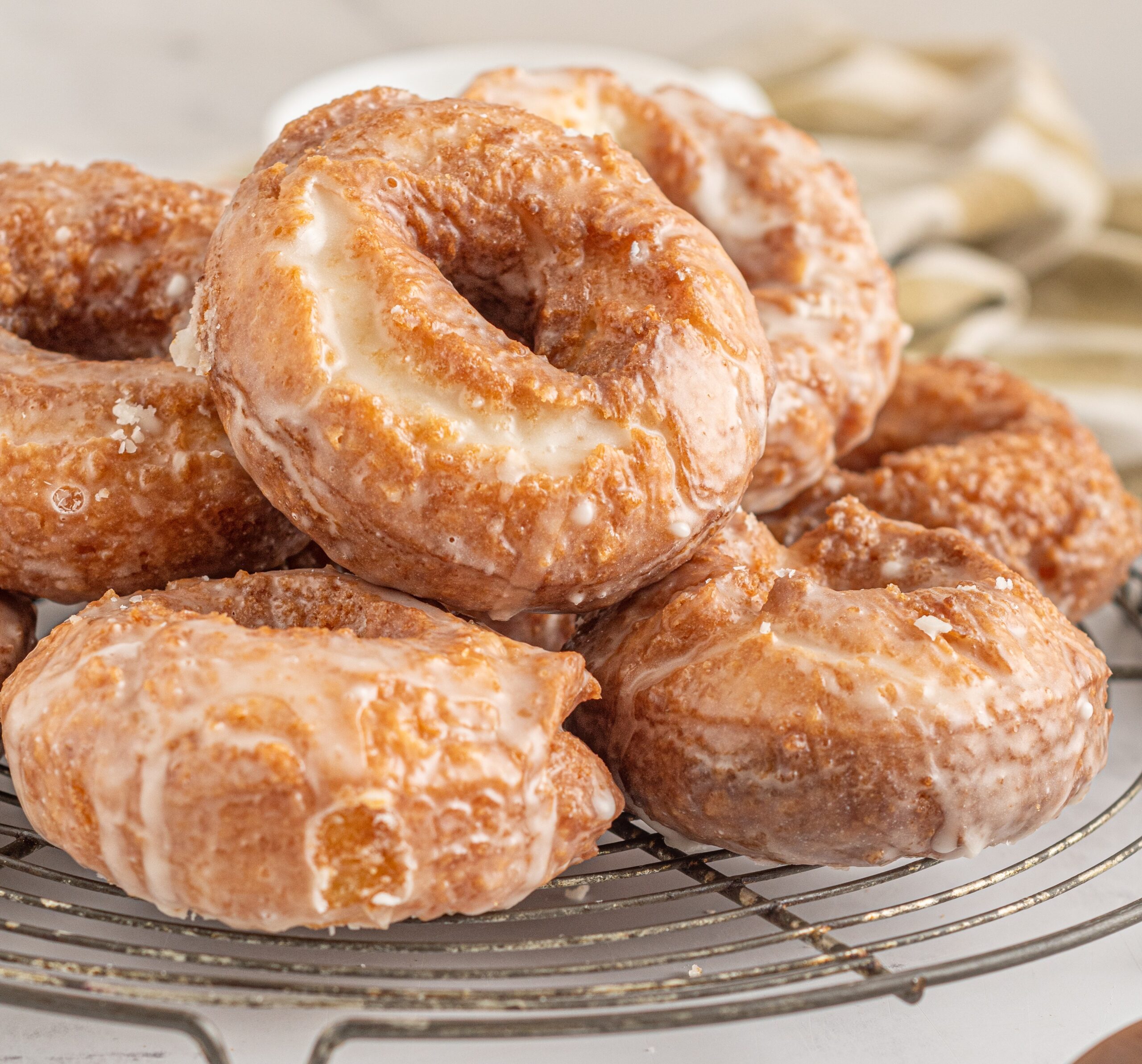 Side view of the donuts stacked on a wire cooling rack.