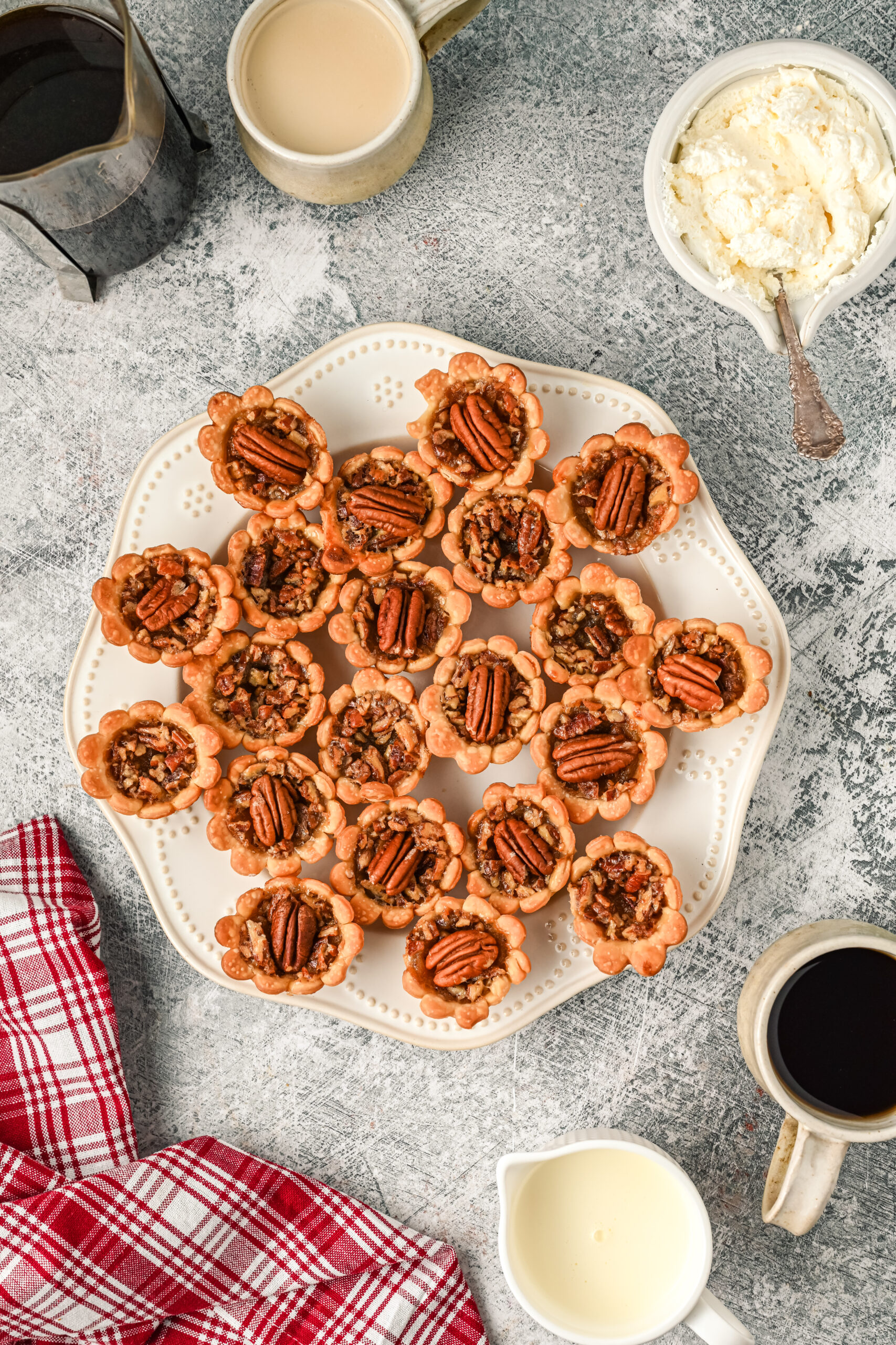 Overhead view of mini pecan pies on a white serving tray.