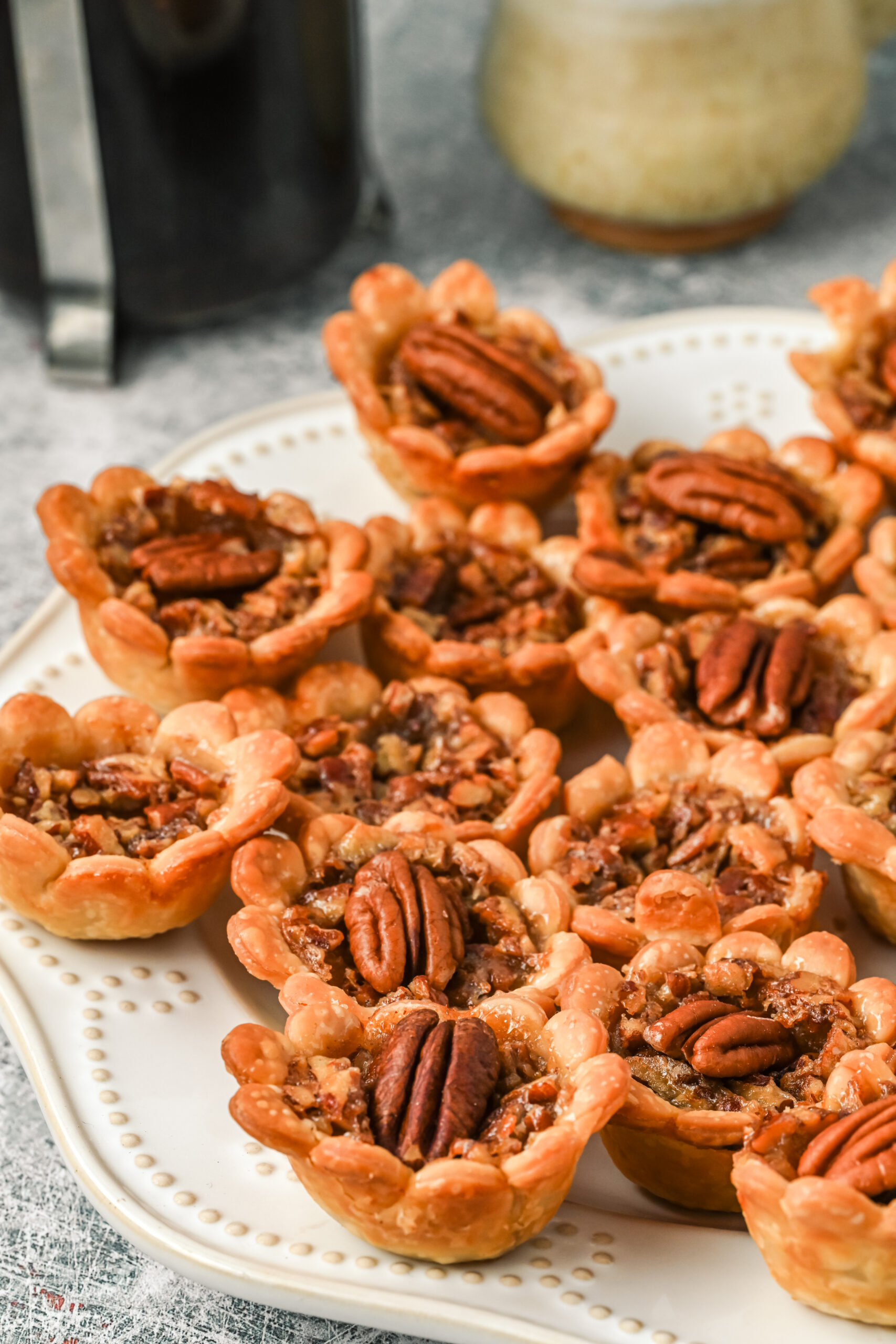 Side view of mini pecan pies on a white serving tray.