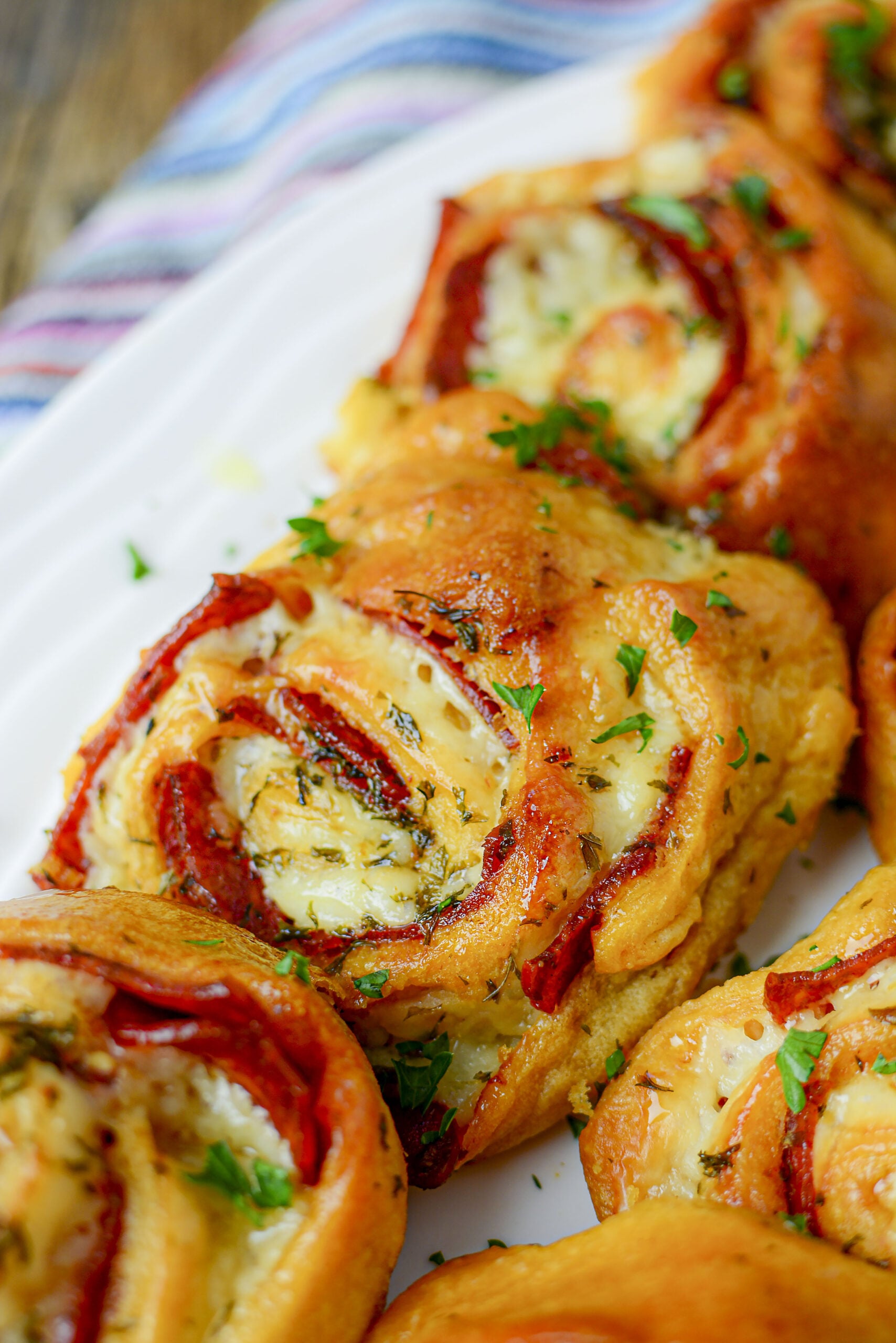 Pizza pinwheels on a white plate lined up