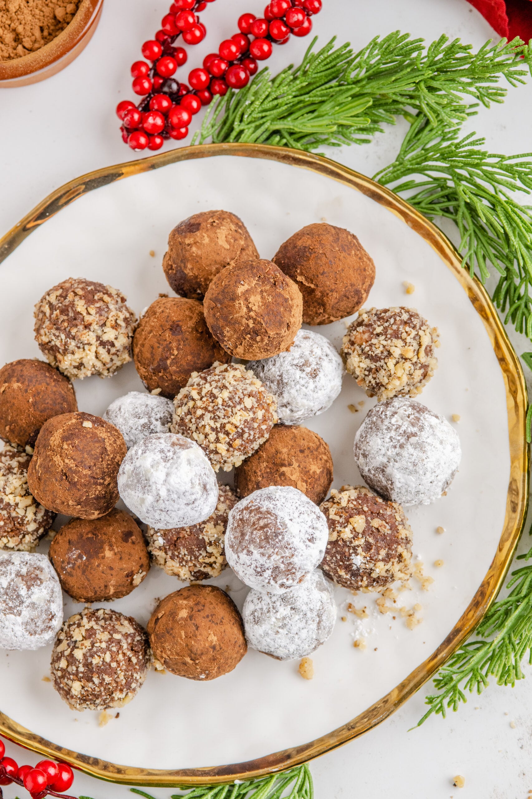 Overhead view of rum balls on a white and gold plate.