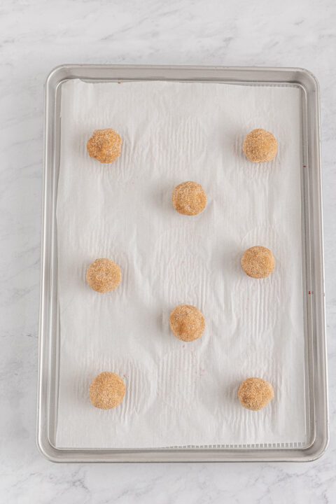 Overhead view of the stuffed cookies rolled into a ball on a baking sheet.