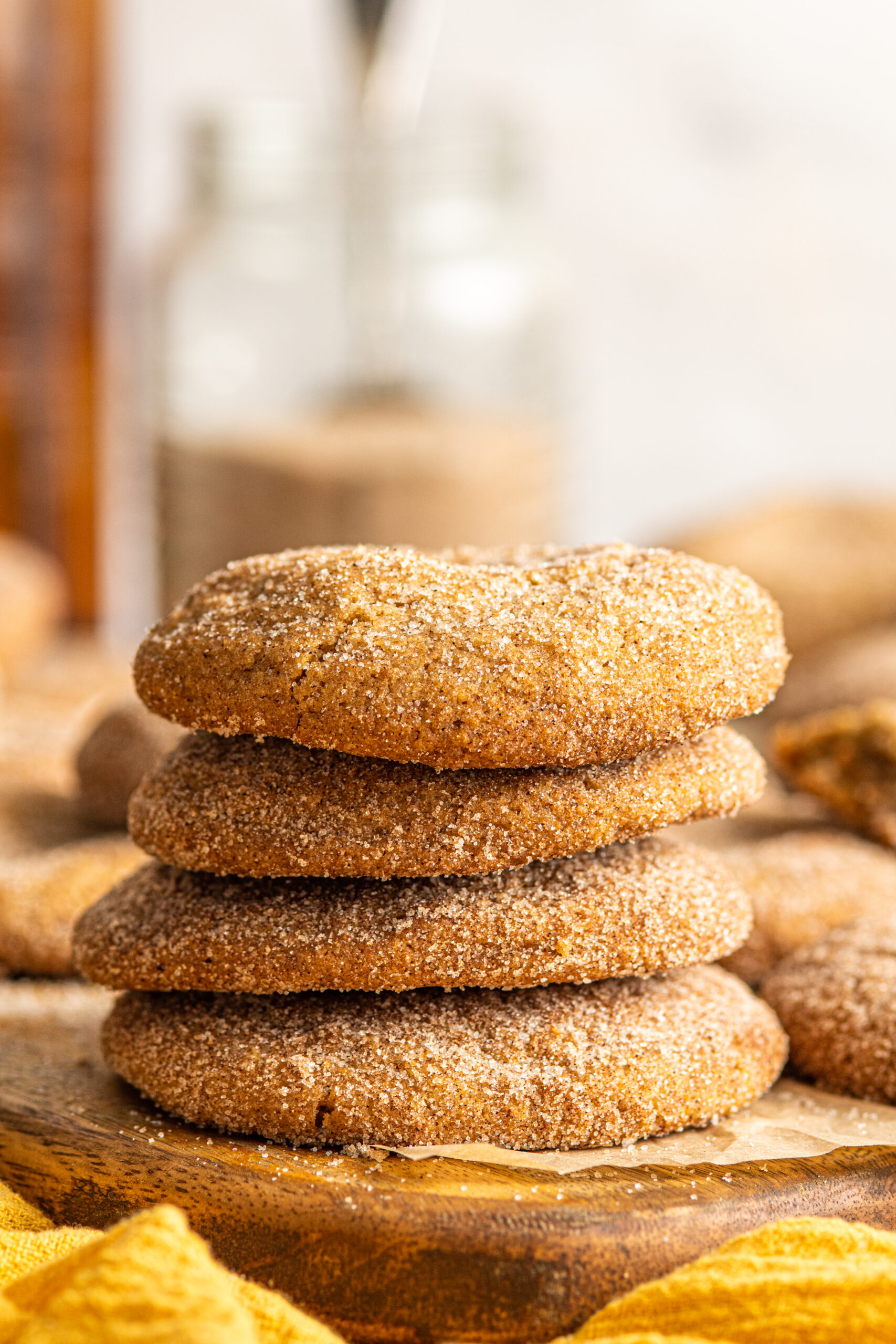 Side view of four stacked Stuffed Churro Cookies on a wooden board.