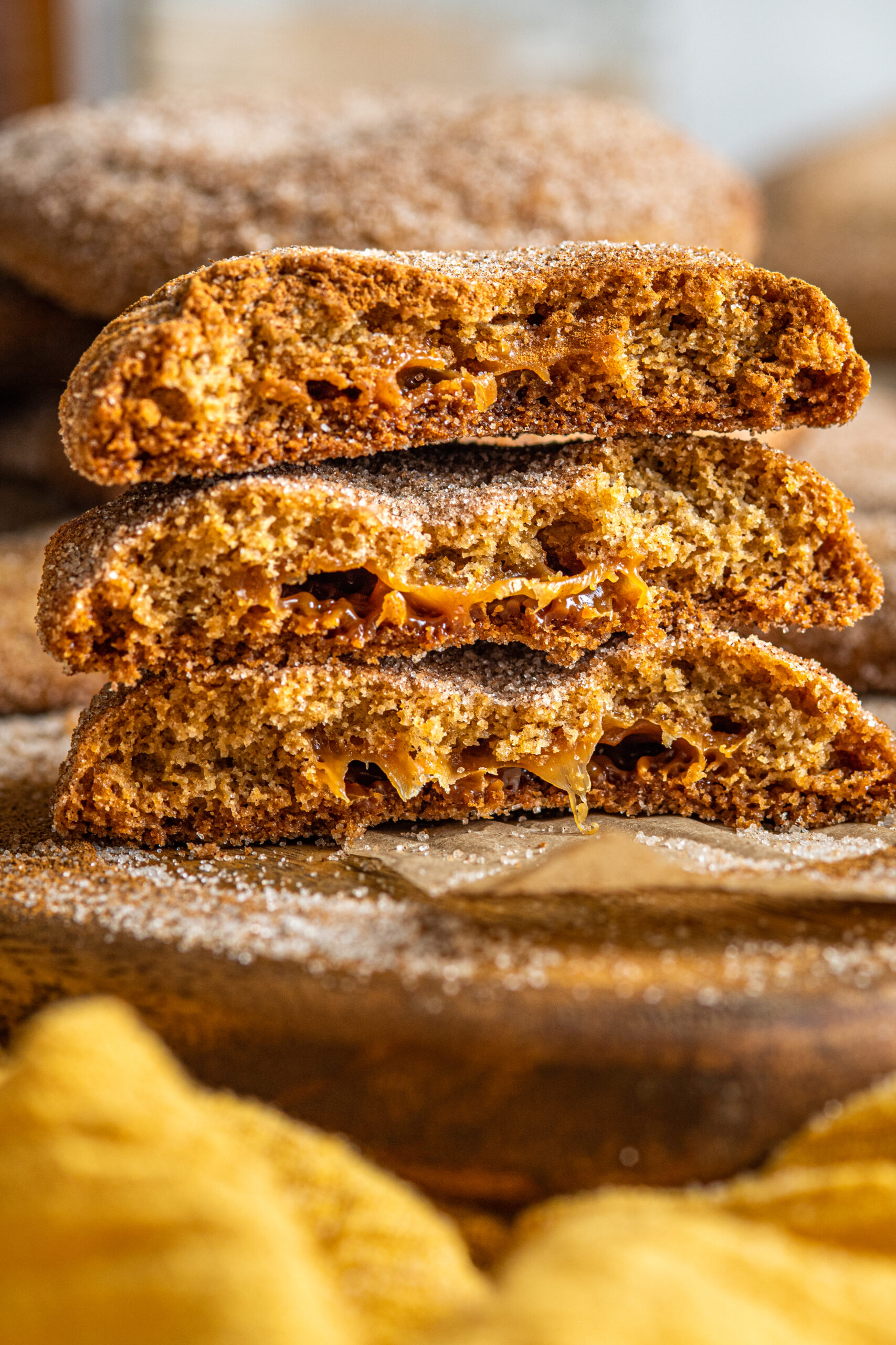 Side view of 3 cookies cut in half showing the gooey inside of each cookie.
