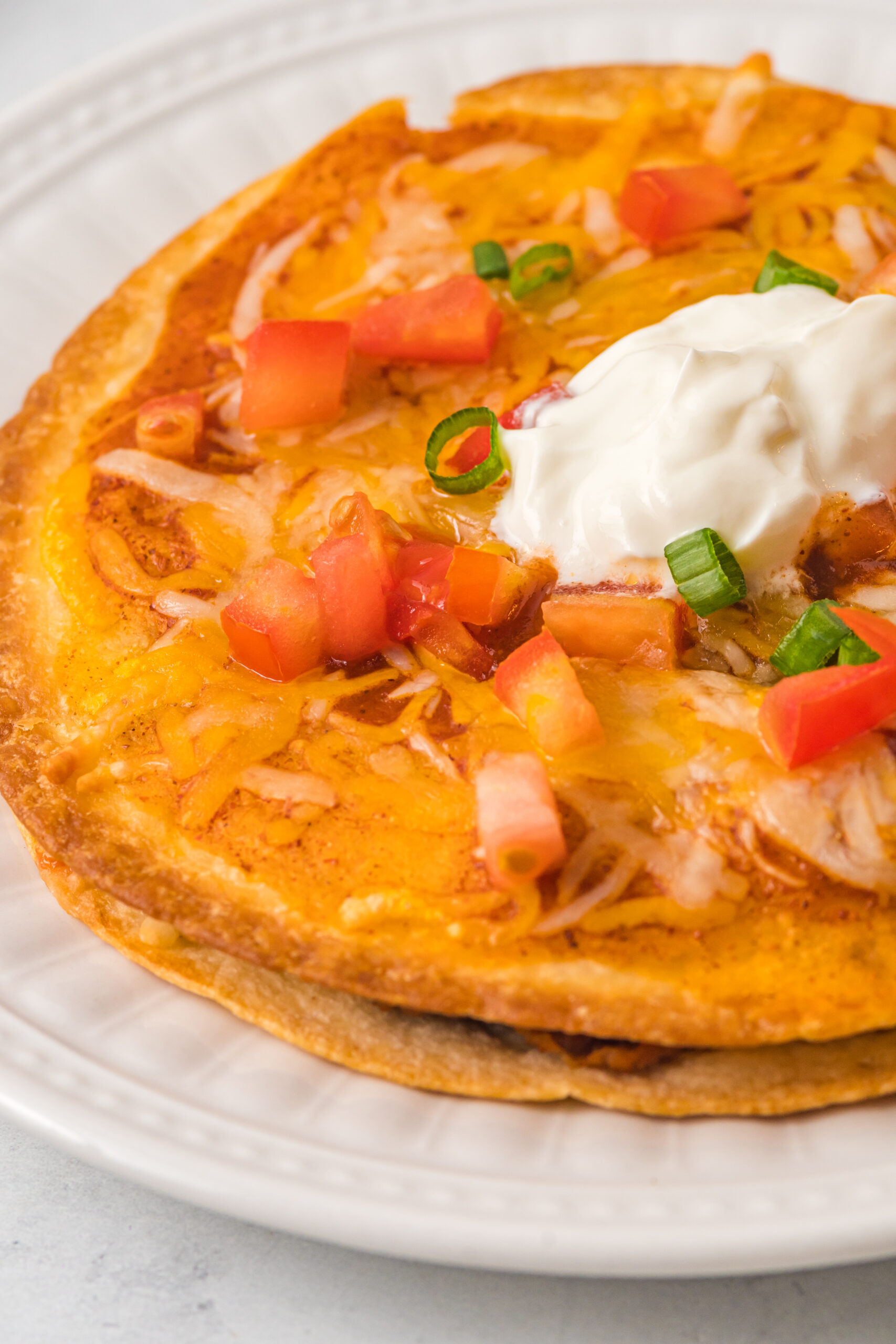 up close shot of a mexican pizza topped with sour cream
