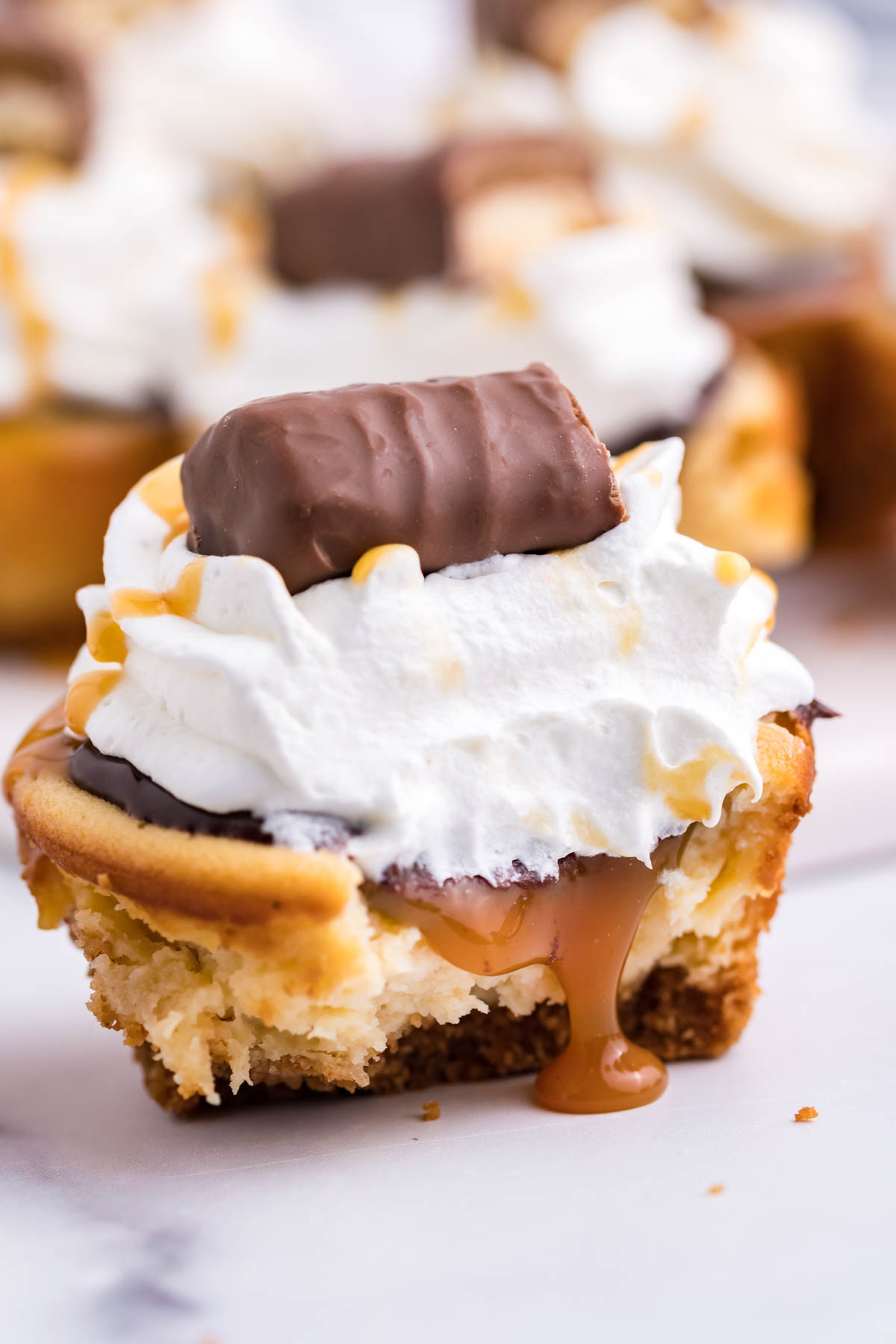 A mini cheesecake cut in half showing the caramel filling.