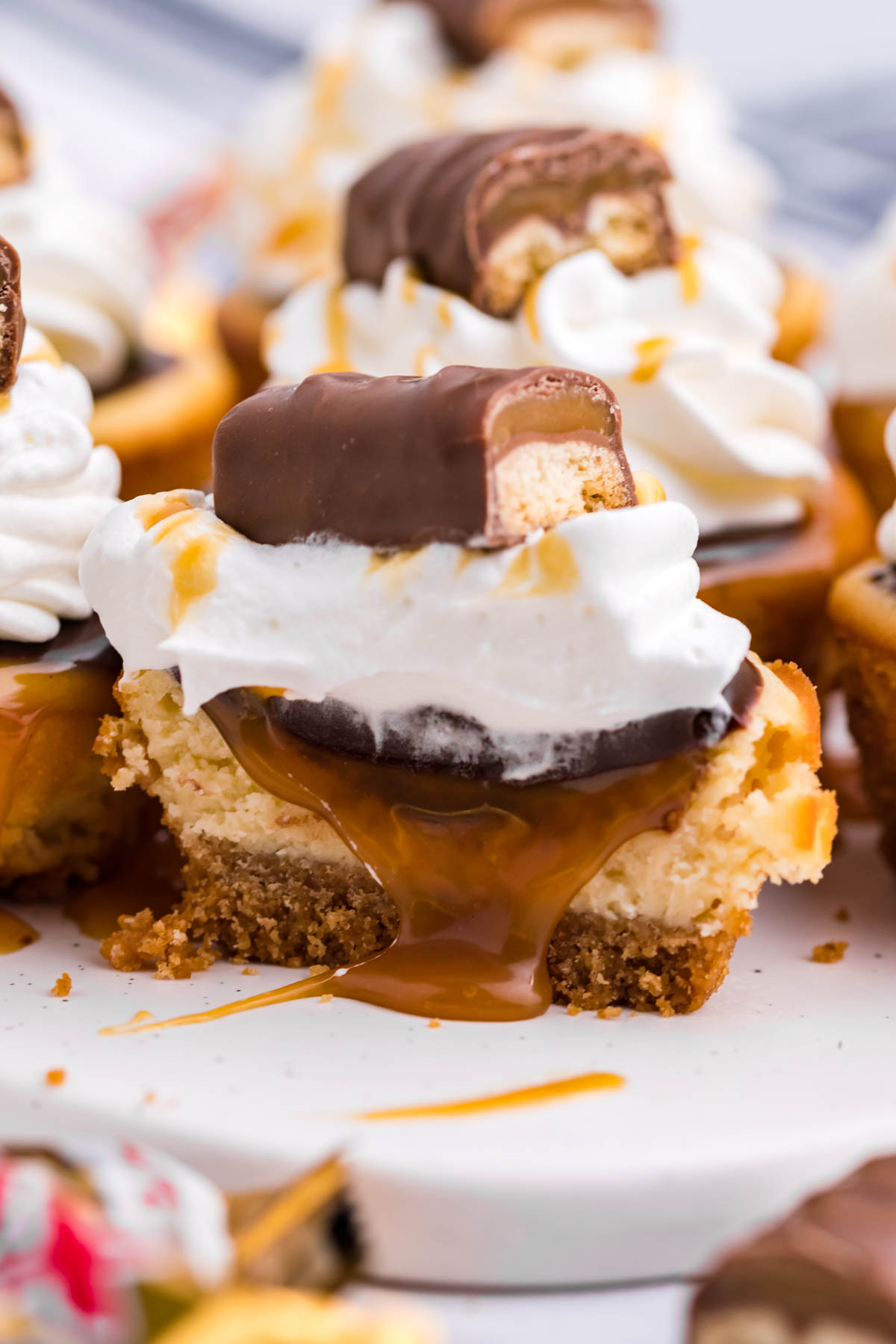 A mini cheesecake cut in half showing the caramel filling.