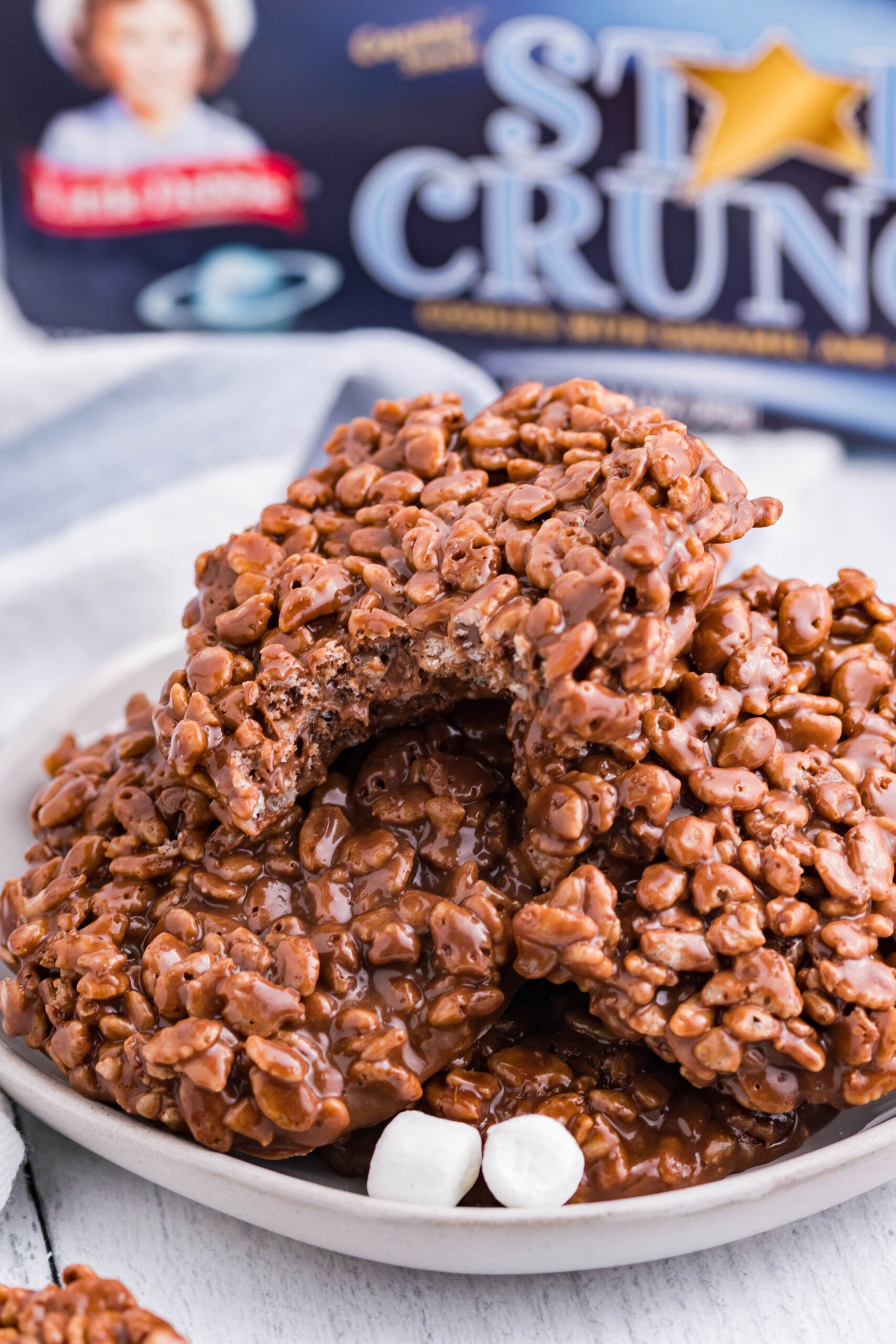 Star Crunch Copycat Cookies stacked on a white plate with marshmallows.
