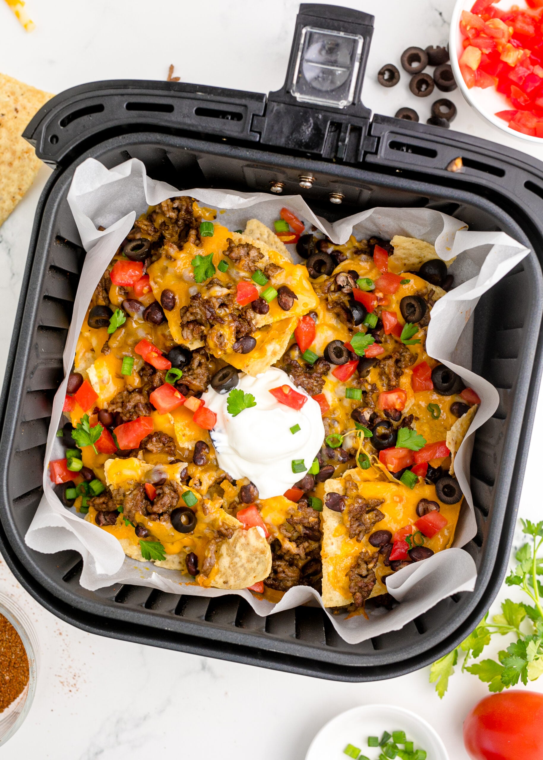 Overhead view of Air Fryer Nachos in an air fryer basket.