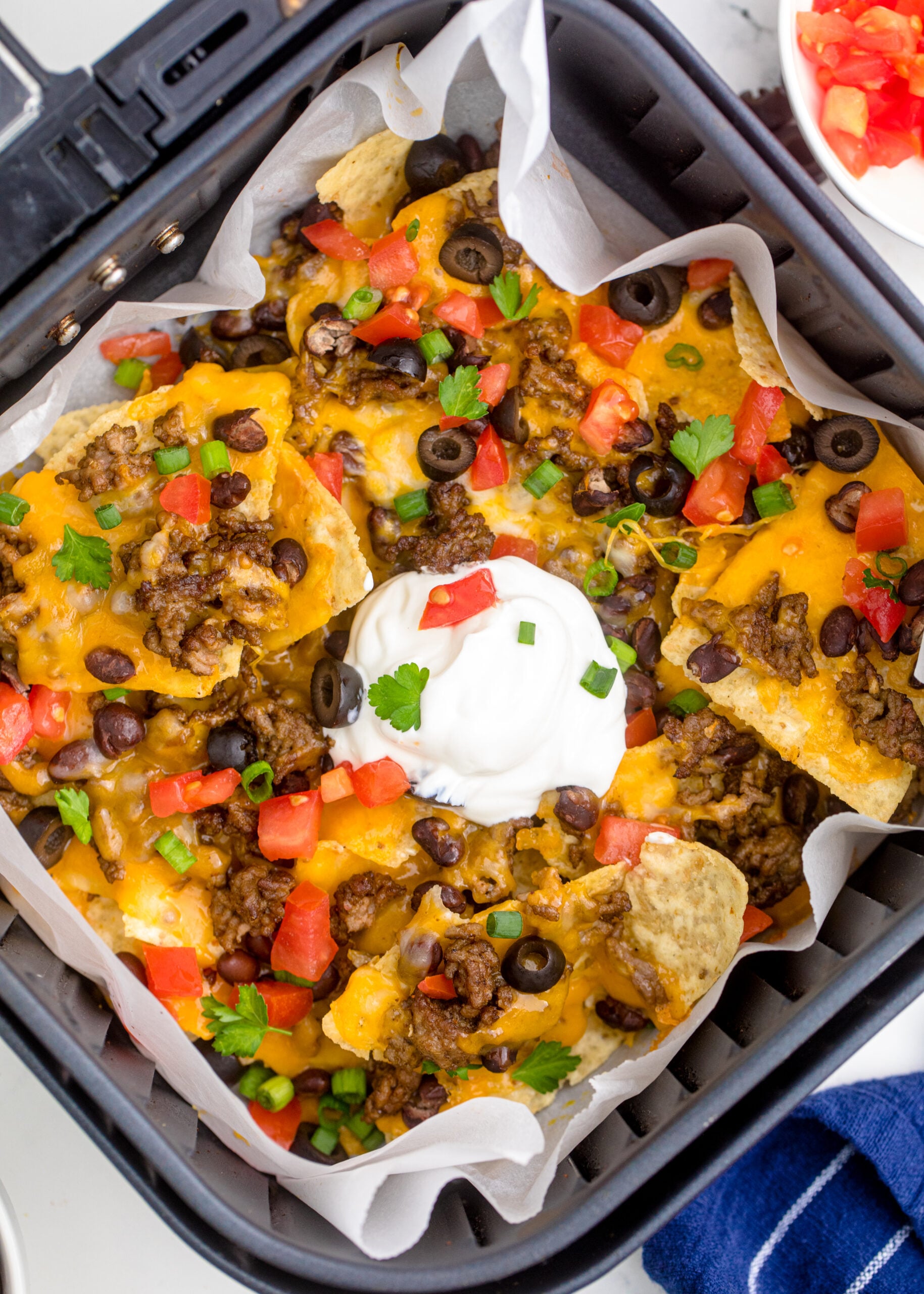 Overhead view of Air Fryer Nachos in an air fryer basket.