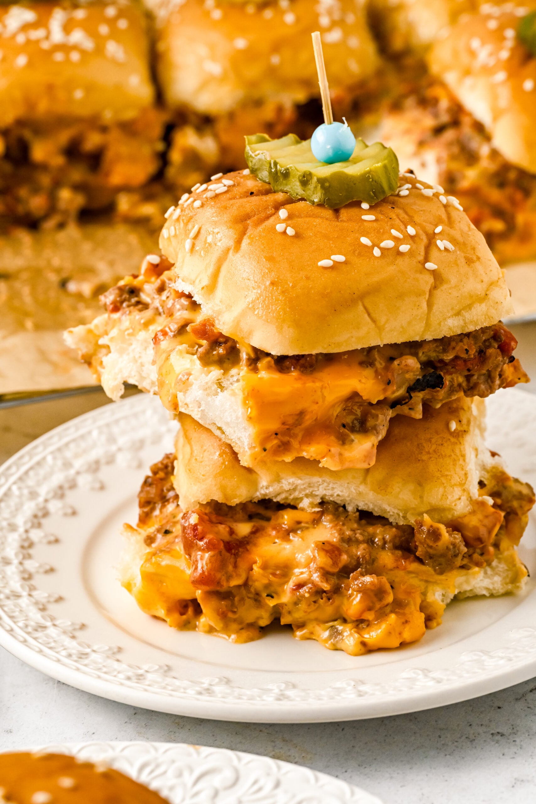 Front view of two Cheeseburger Sliders stacked on a white dish.