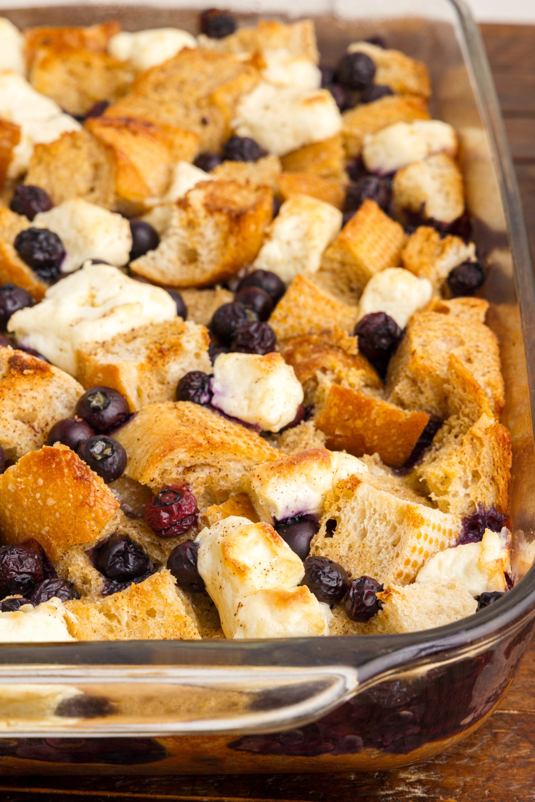 Up close view of Blueberry French Toast Casserole in a clear baking dish.