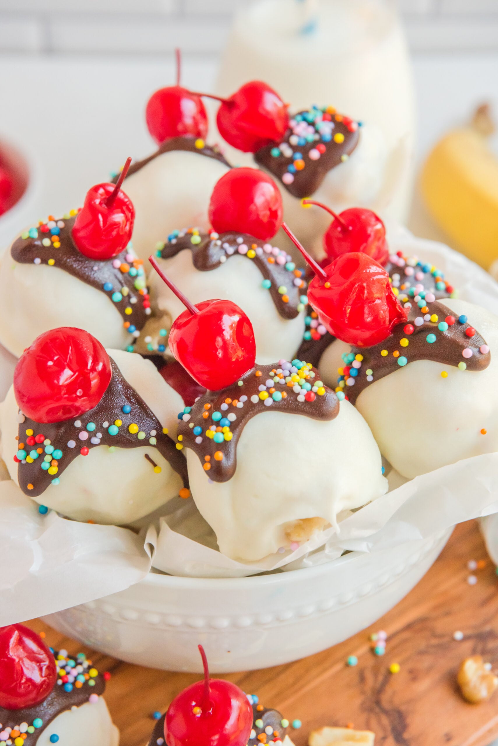 Front view of Banana Truffles stacked in a white dish lined with parchment paper.