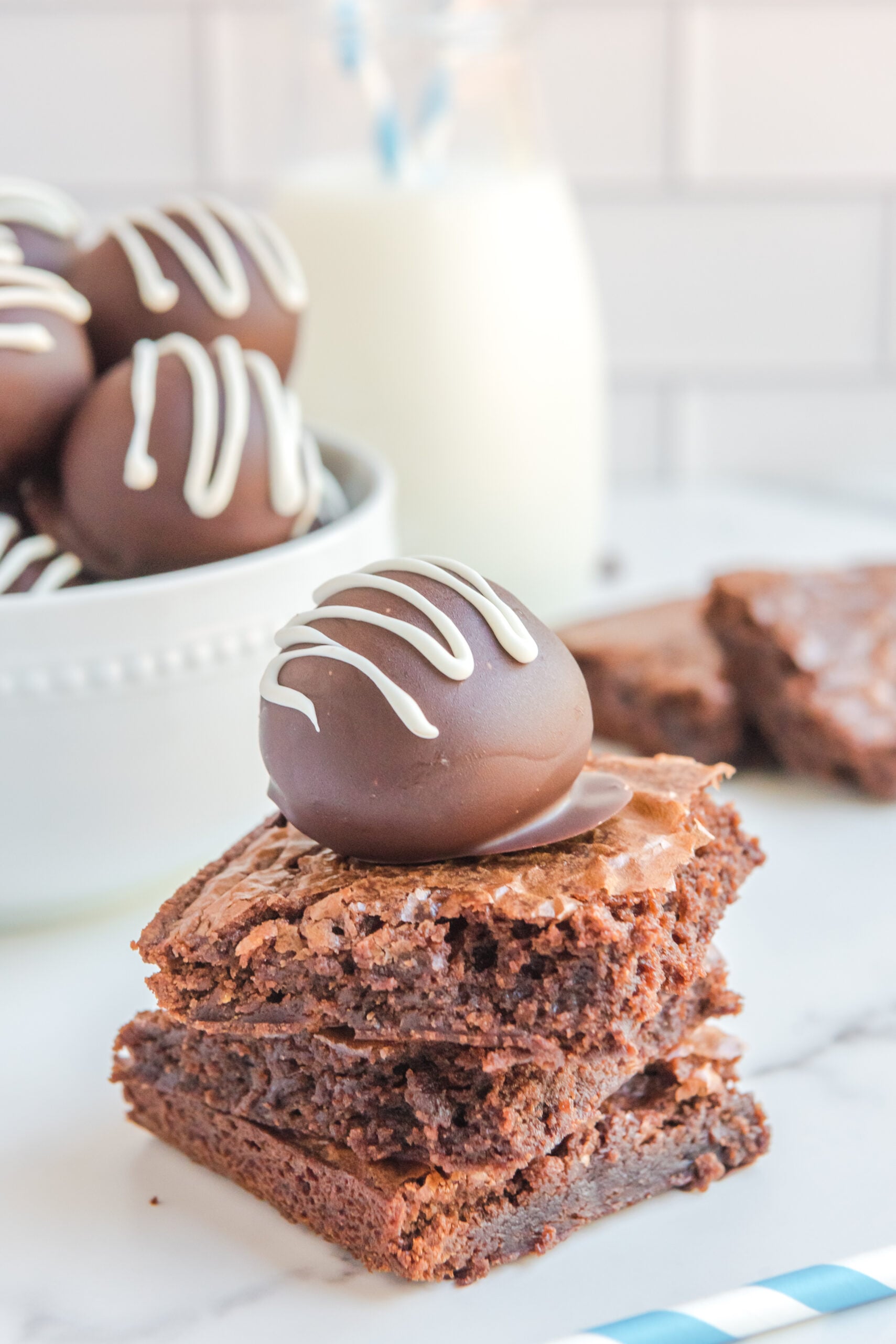 A brownie truffle stacked on three brownies.
