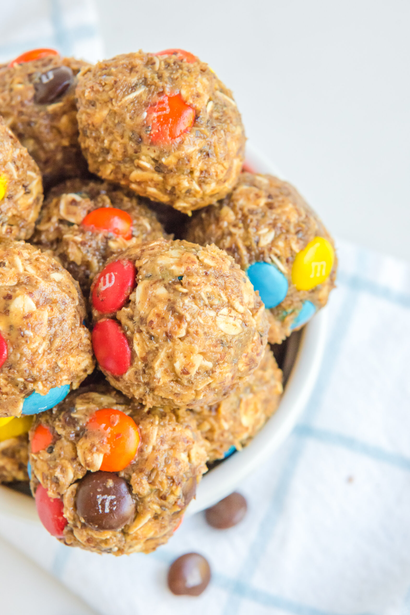 Close up view of No Bake M&M Energy balls in a white bowl.
