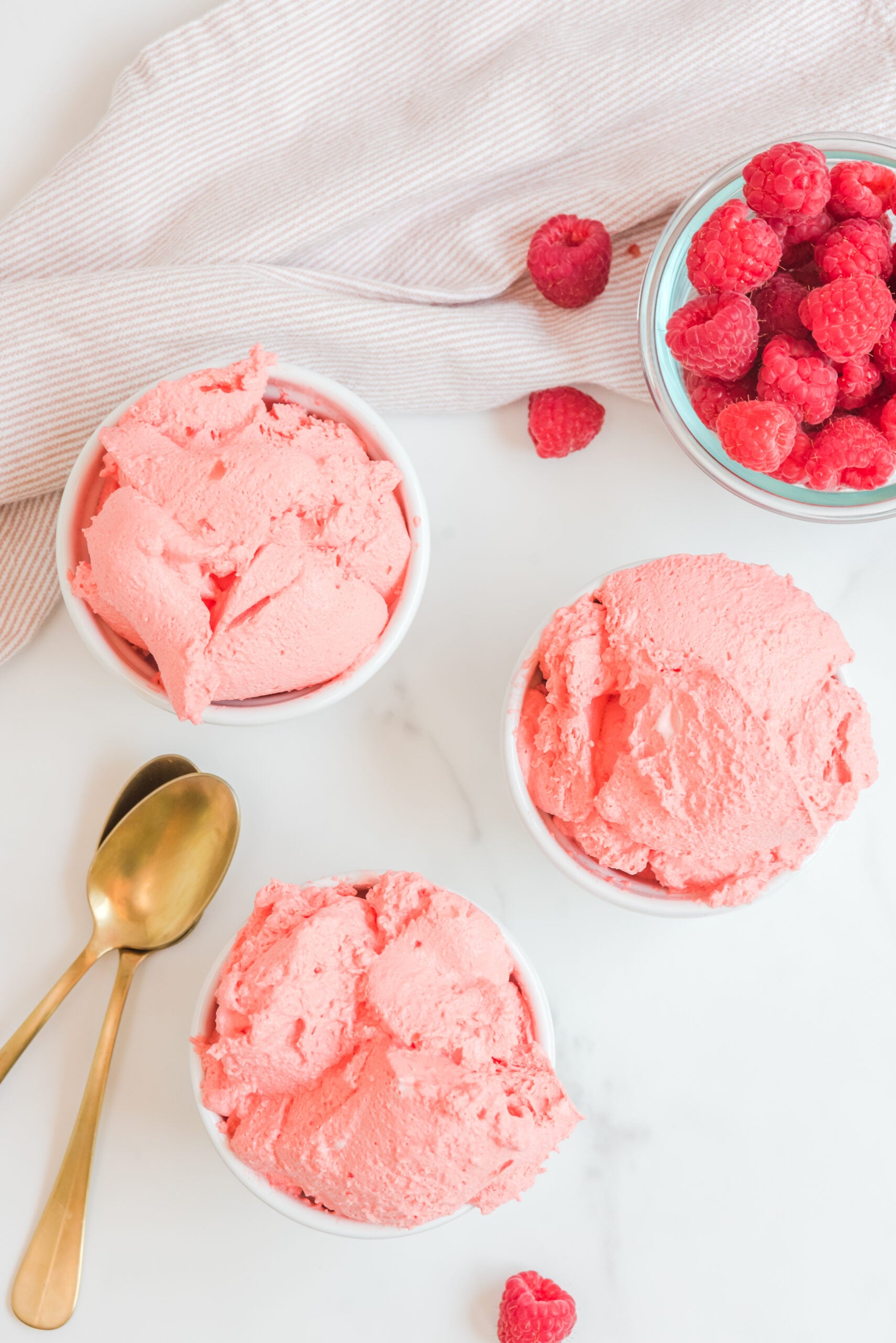 Overhead view of Raspberry Jello Fluff in three white dishes.