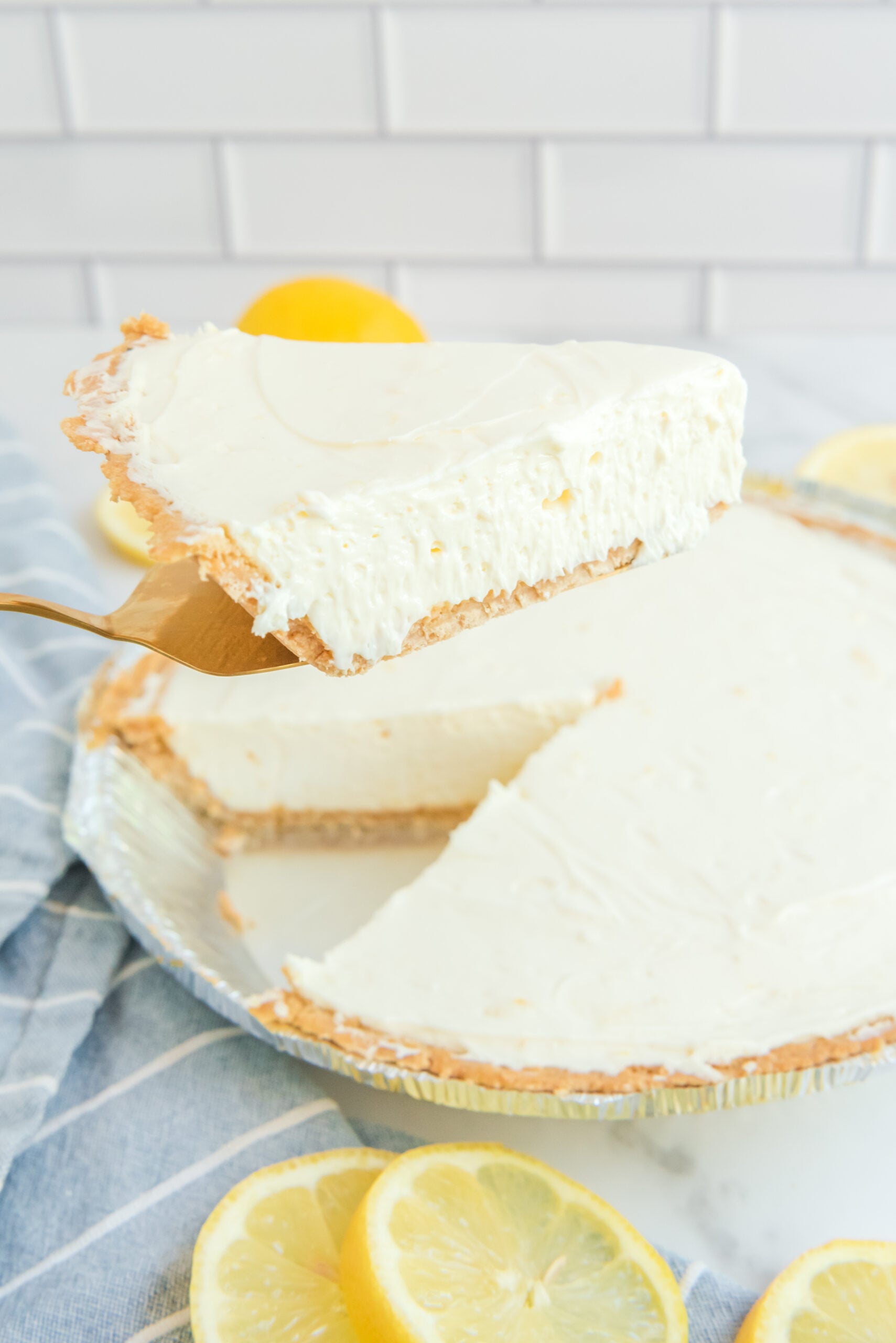 Front view of a slice of No Bake Lemon Cheesecake on a gold cake server.