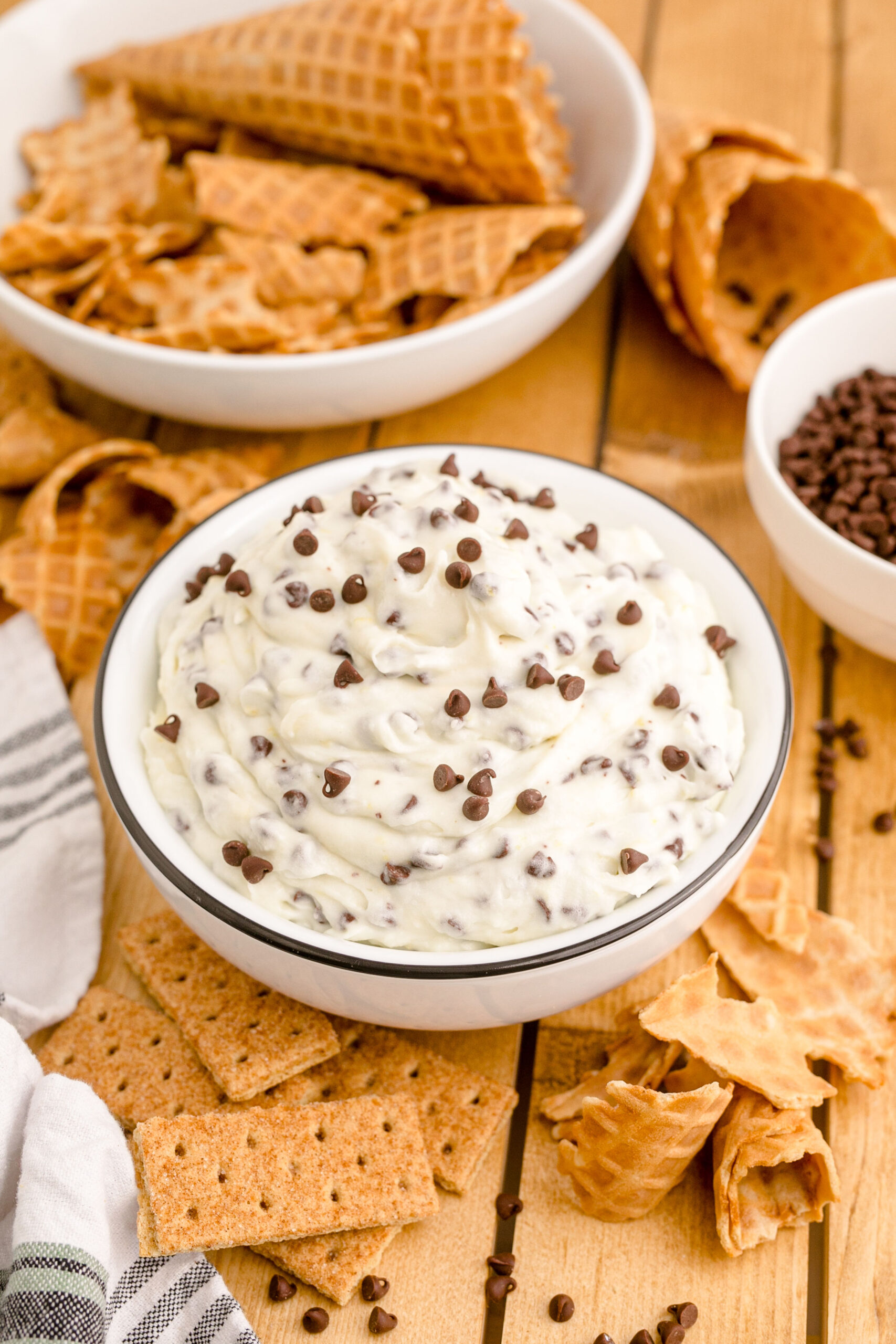 Side view of Cannoli Dip in a black and white dish on a wooden table