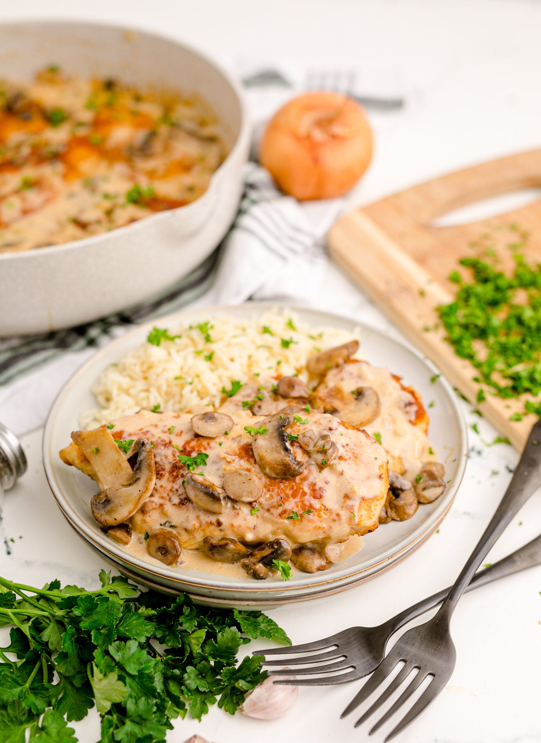 View of Chicken Marsala on a white dish served with white rice.