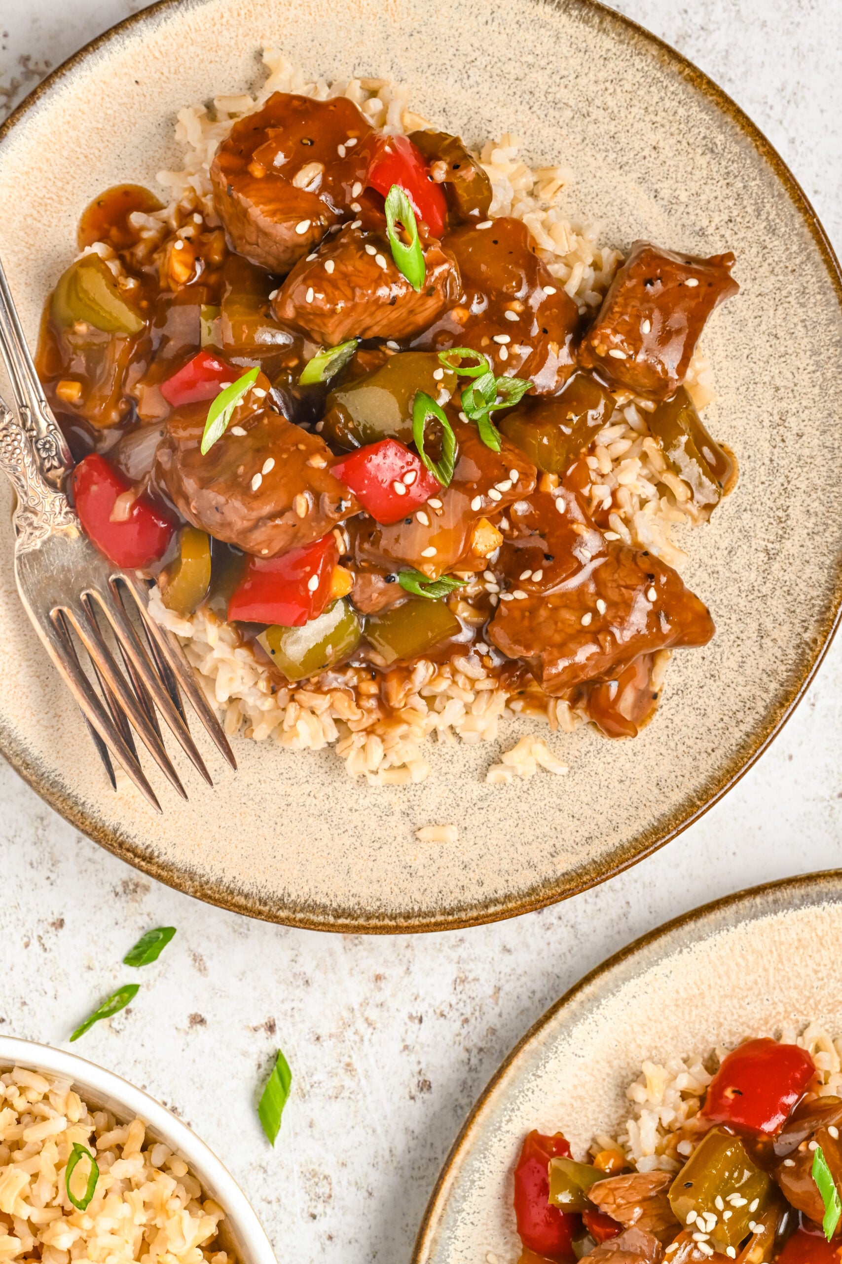 Overhead view of Chinese Pepper Steak on a dish served over rice.