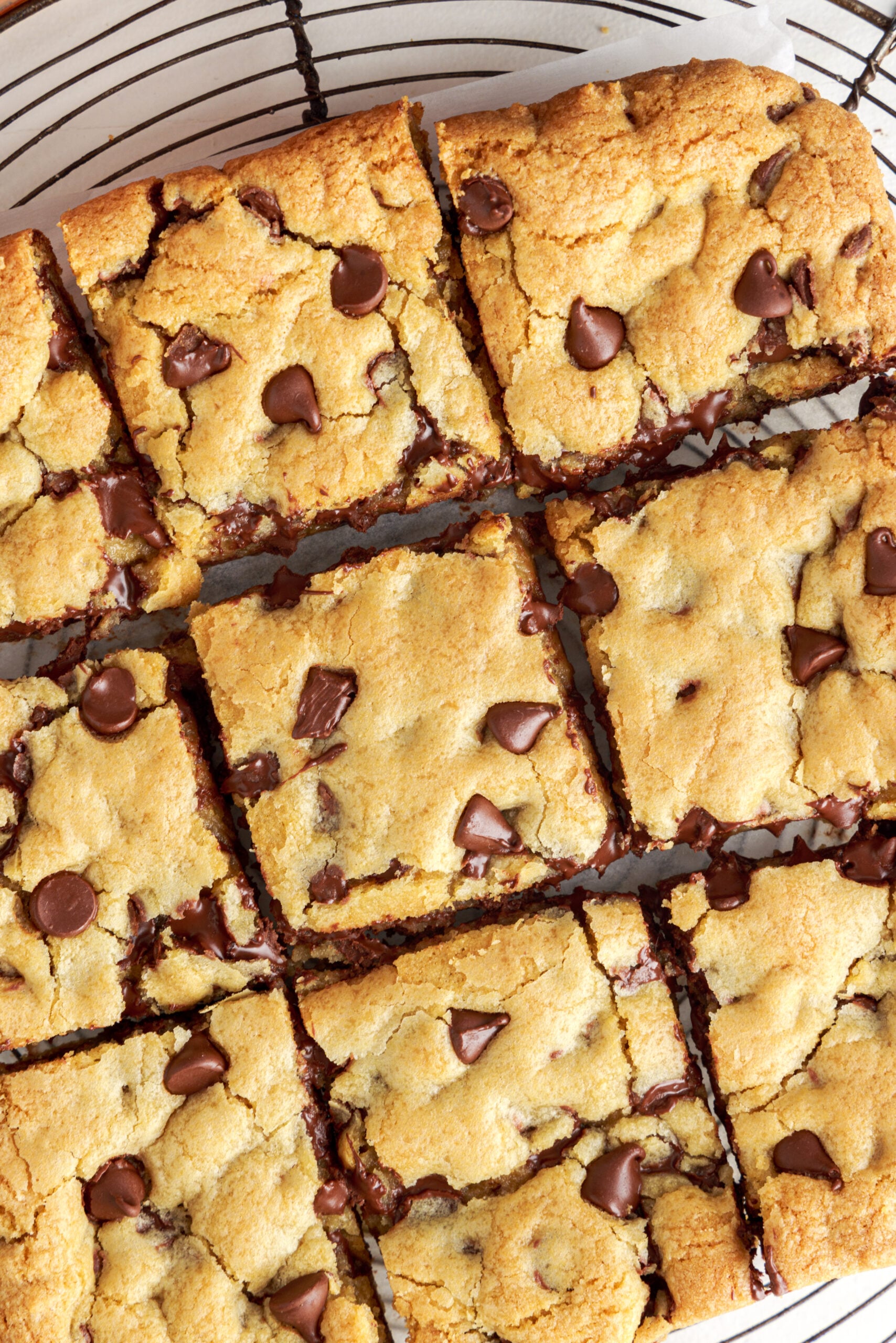 Overhead view of Gooey Chocolate Chip Cookie bars cut into nine squares on a wire rack 