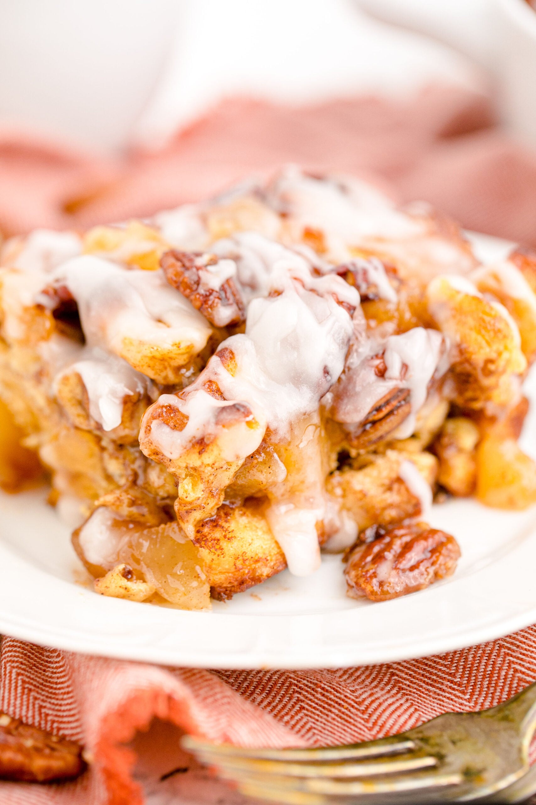 Cinnamon Roll Casserole on a white dish topped with icing.