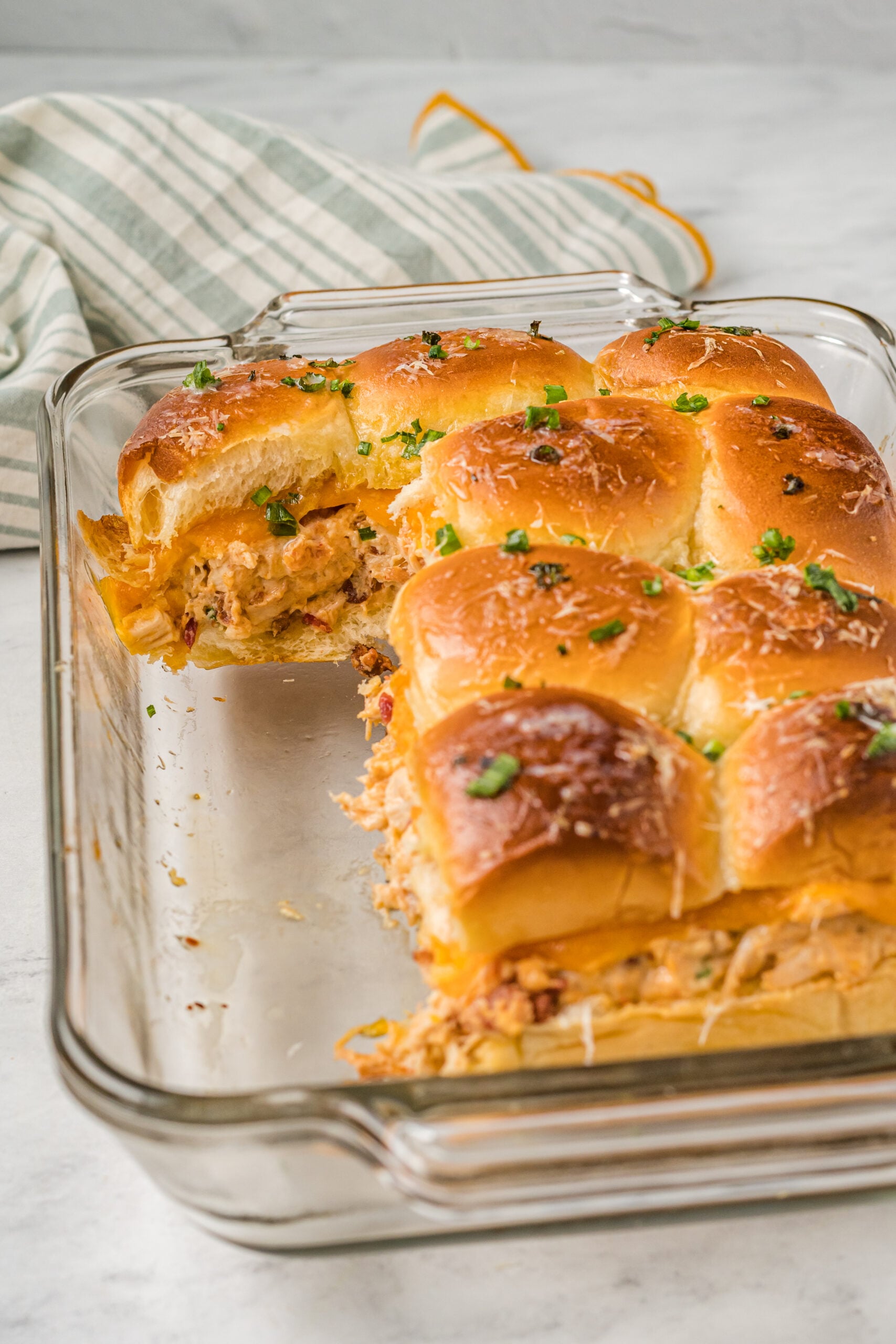 Front view of Crack Chicken Sliders in a clear baking dish.