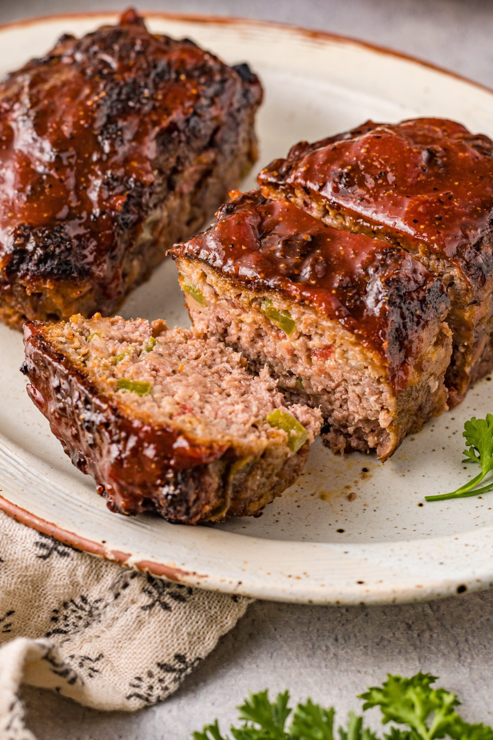 Front view of Cracker Barrel Meatloaf on a serving dishes with slices cut from the meatloaf.