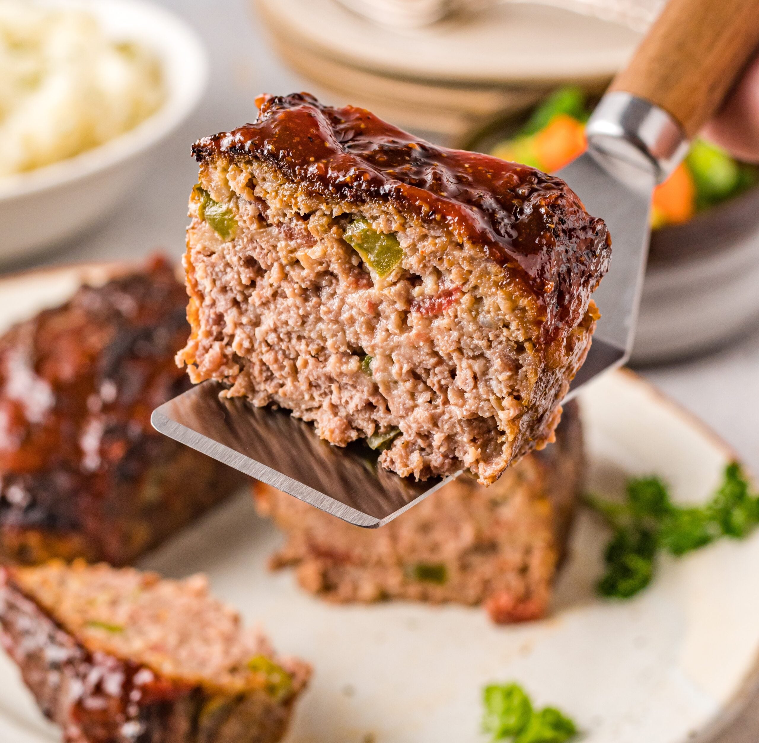 Cracker Barrel Meatloaf slice being held up on a spatula