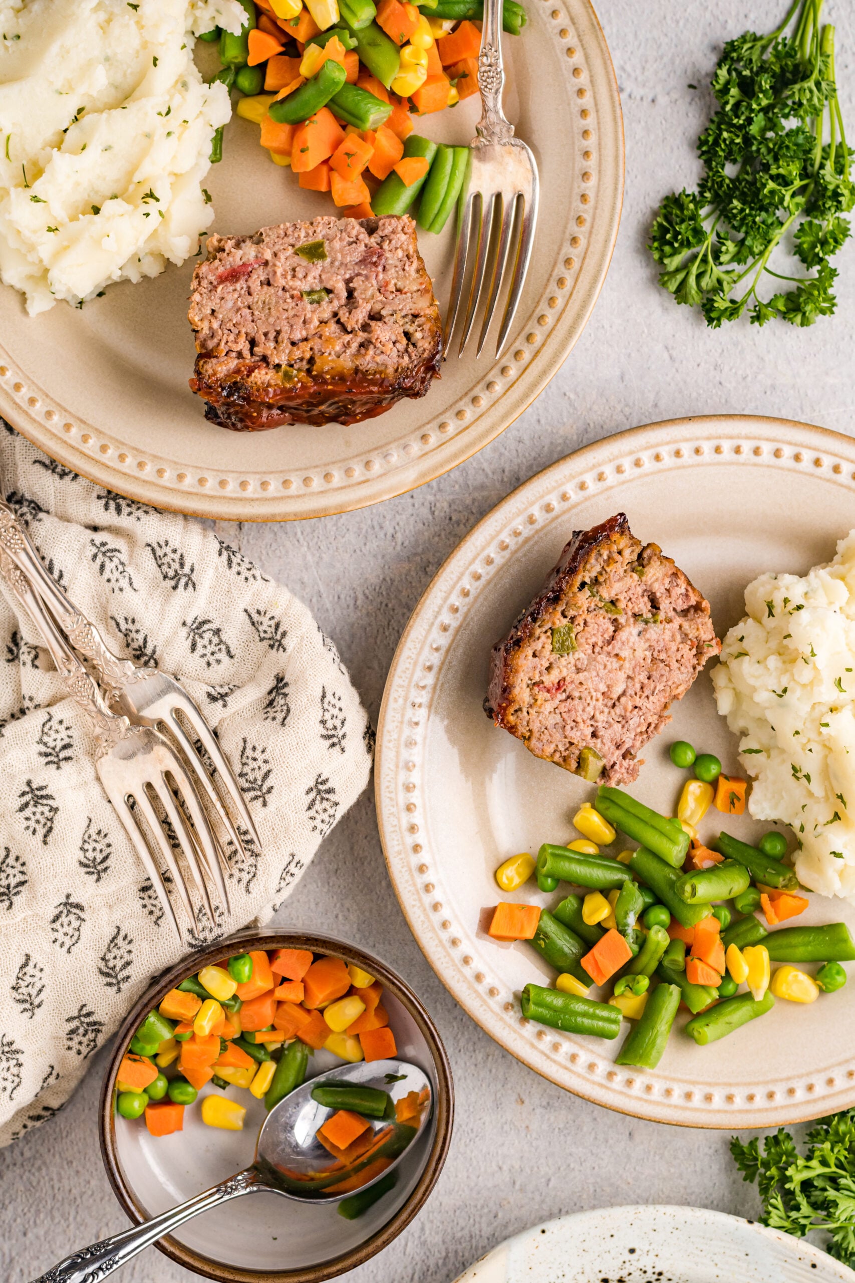 Overhead view of Cracker Barrel Meatloaf slices served with mashed potatoes and mixed vegetables.