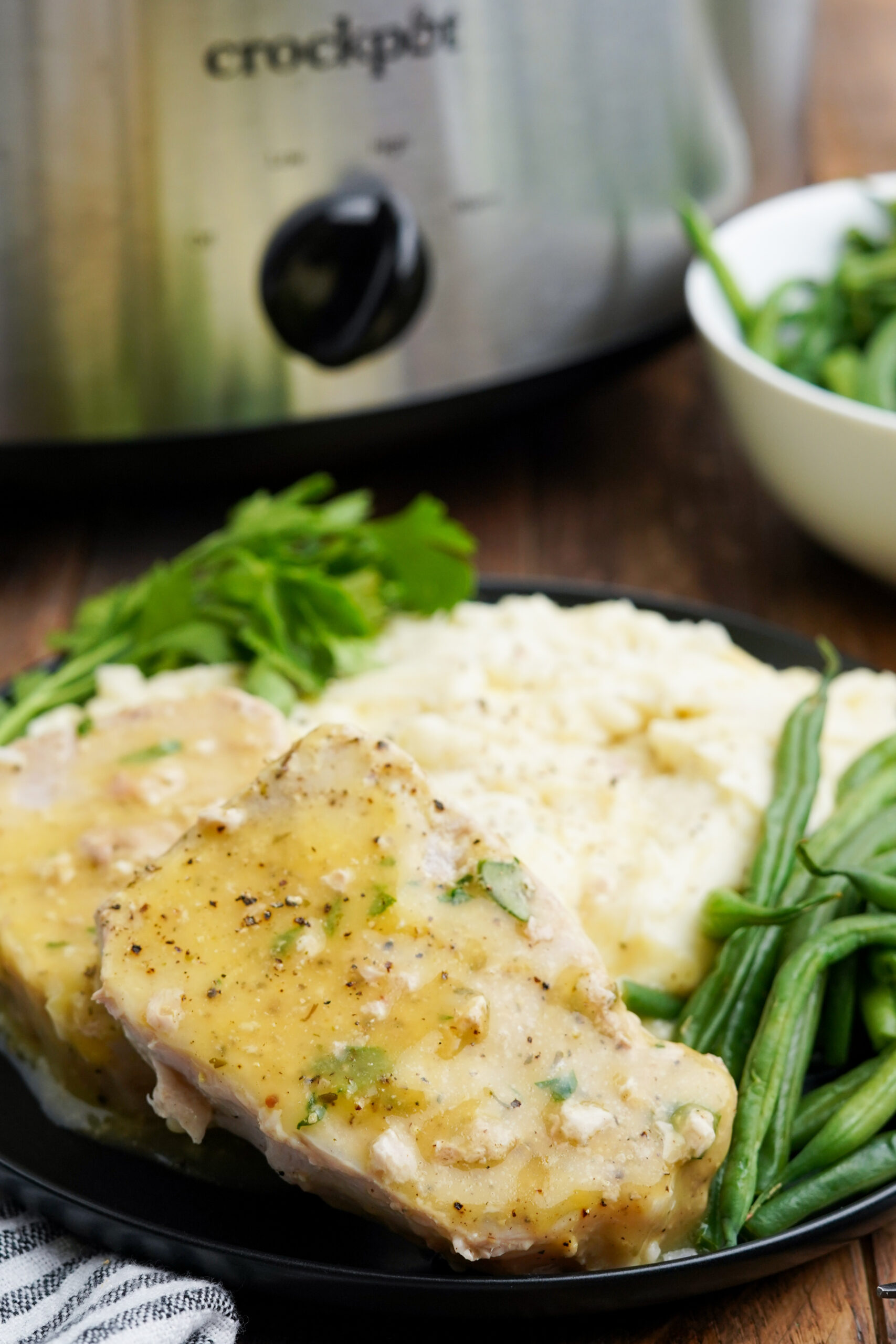Close up view of Crock Pot Ranch Pork Chops served with mashed potatoes and green beans.
