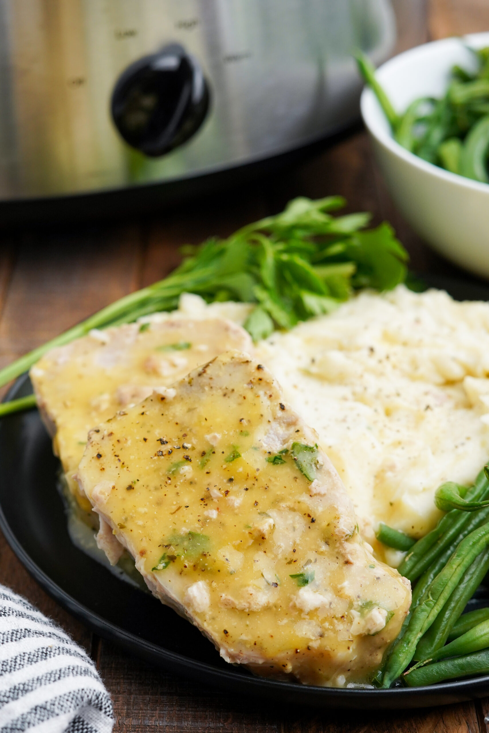 Close up view of Crock Pot Ranch Pork Chops served with mashed potatoes and green beans.
