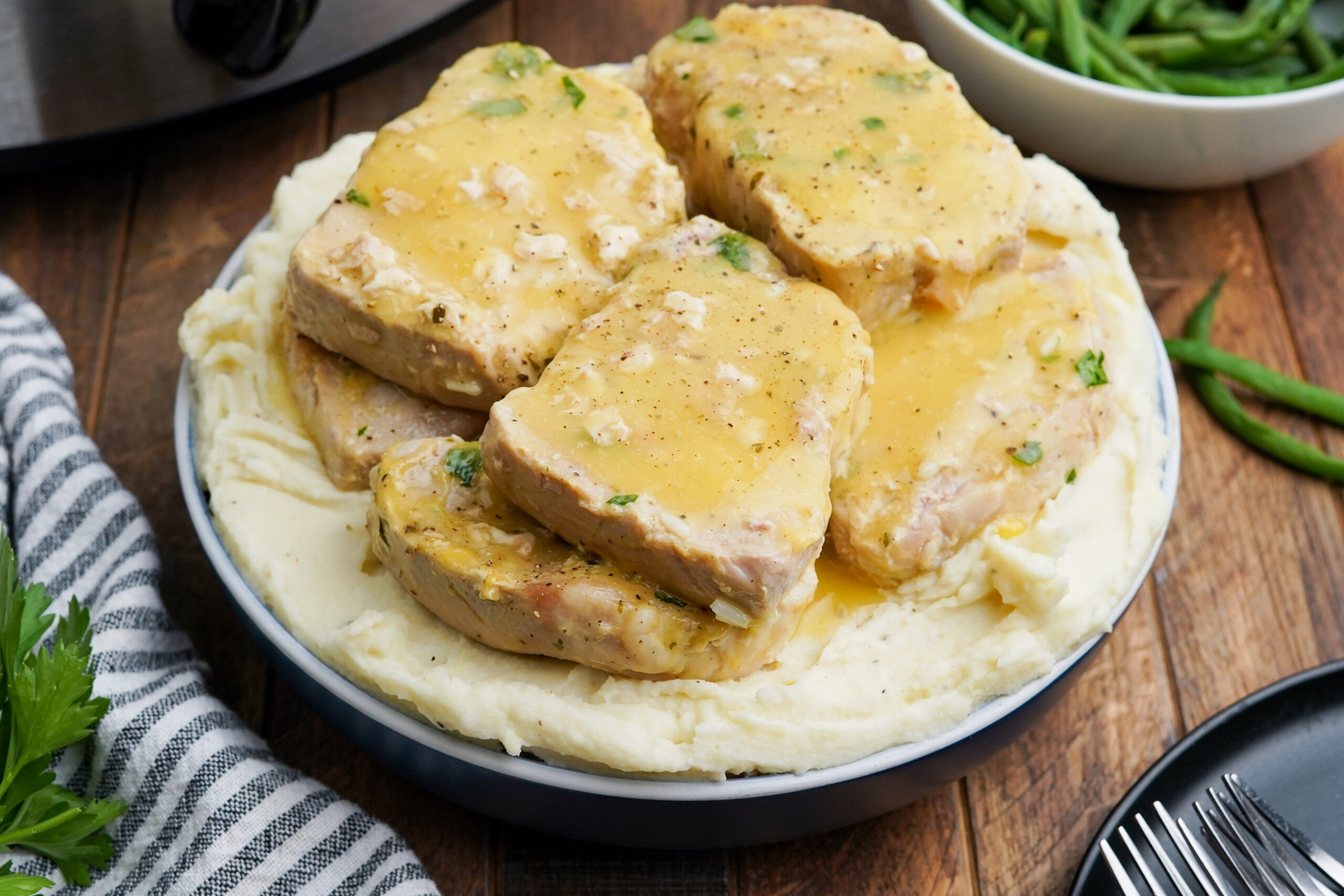 Front view of Crock Pot Ranch Pork Chops served over mashed potatoes.
