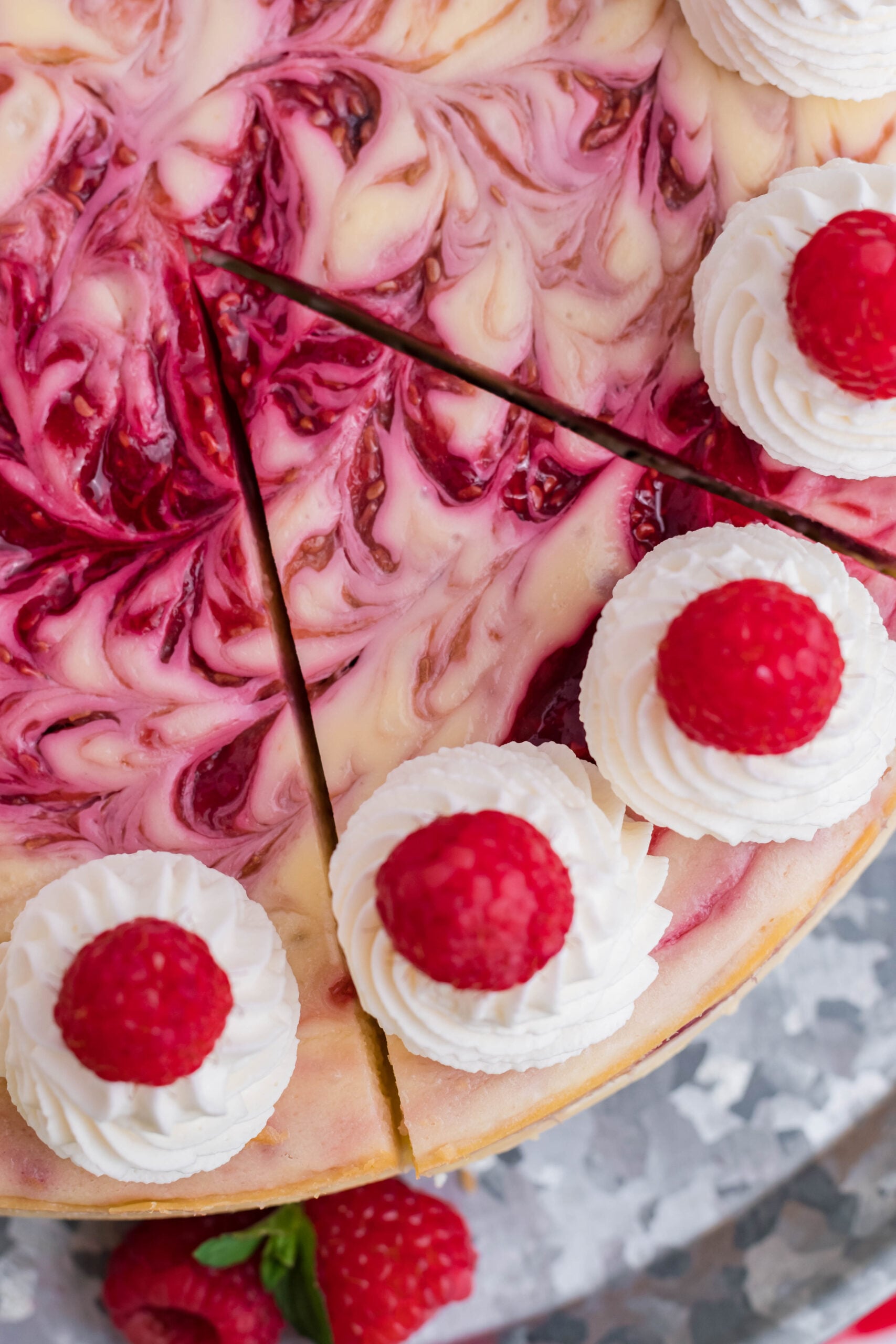 Close up overhead view of Raspberry Swirl Cheesecake with a slice cut.