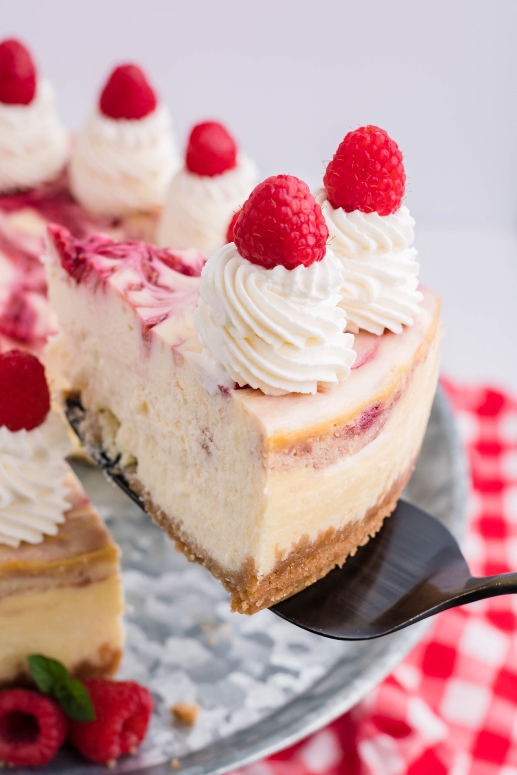 Raspberry Swirl Cheesecake slice being lifted up