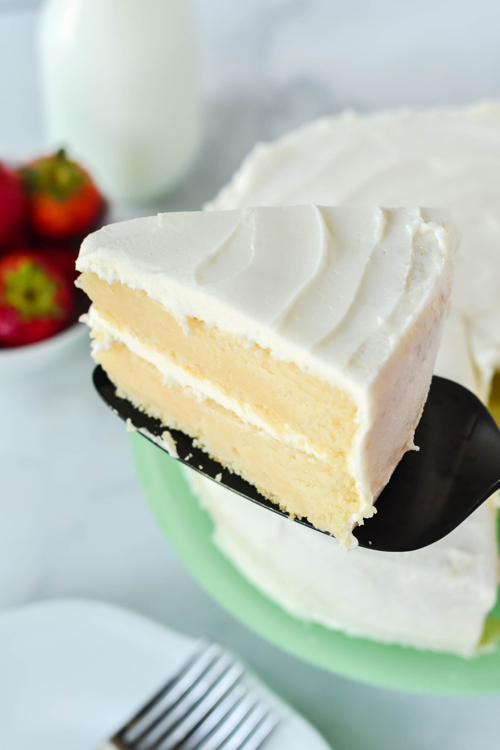 Side view of a slice of Classic Vanilla Cake on a black cake server.