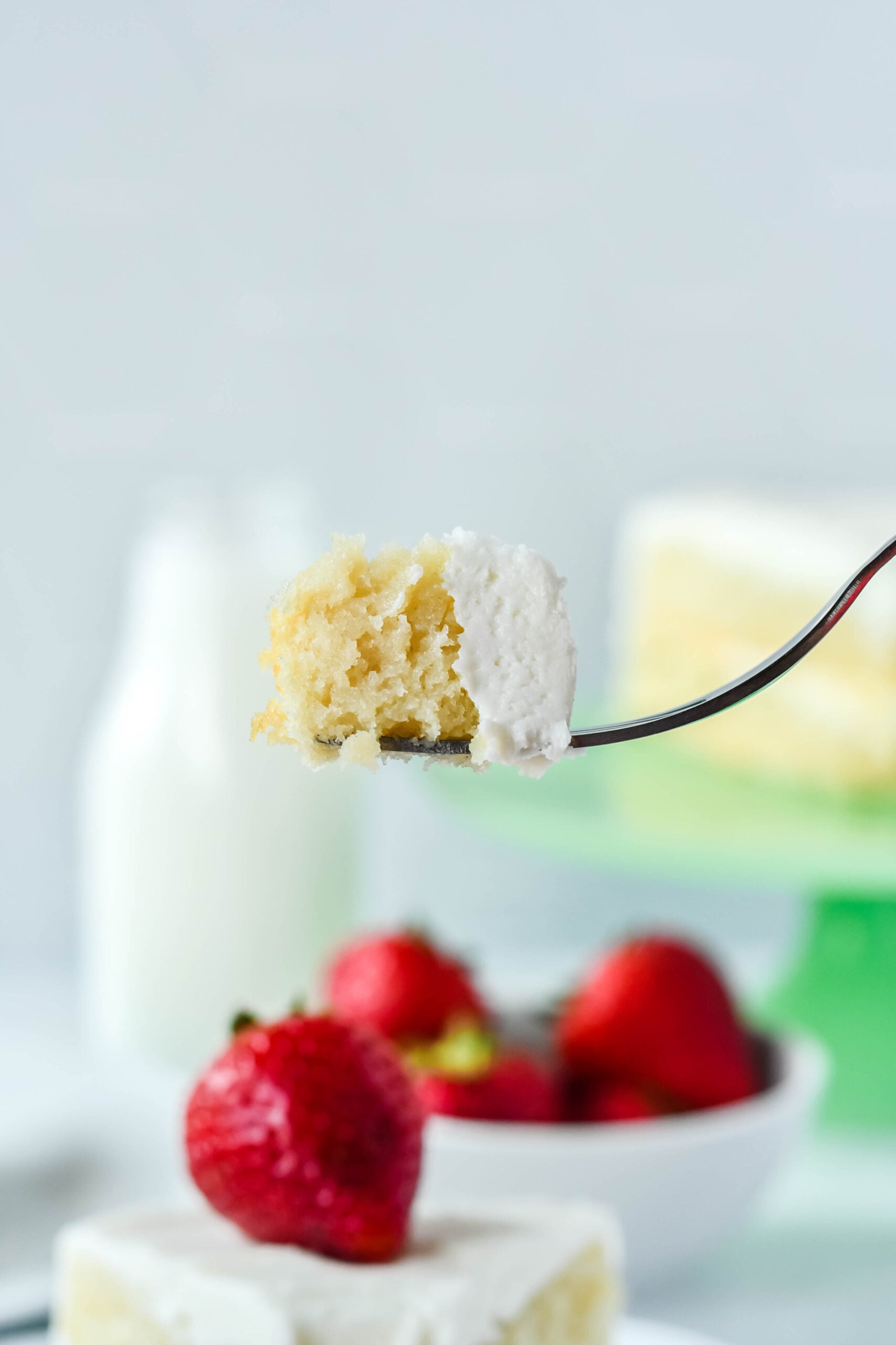 Side view of a bite of Classic Vanilla Cake on a silver fork.