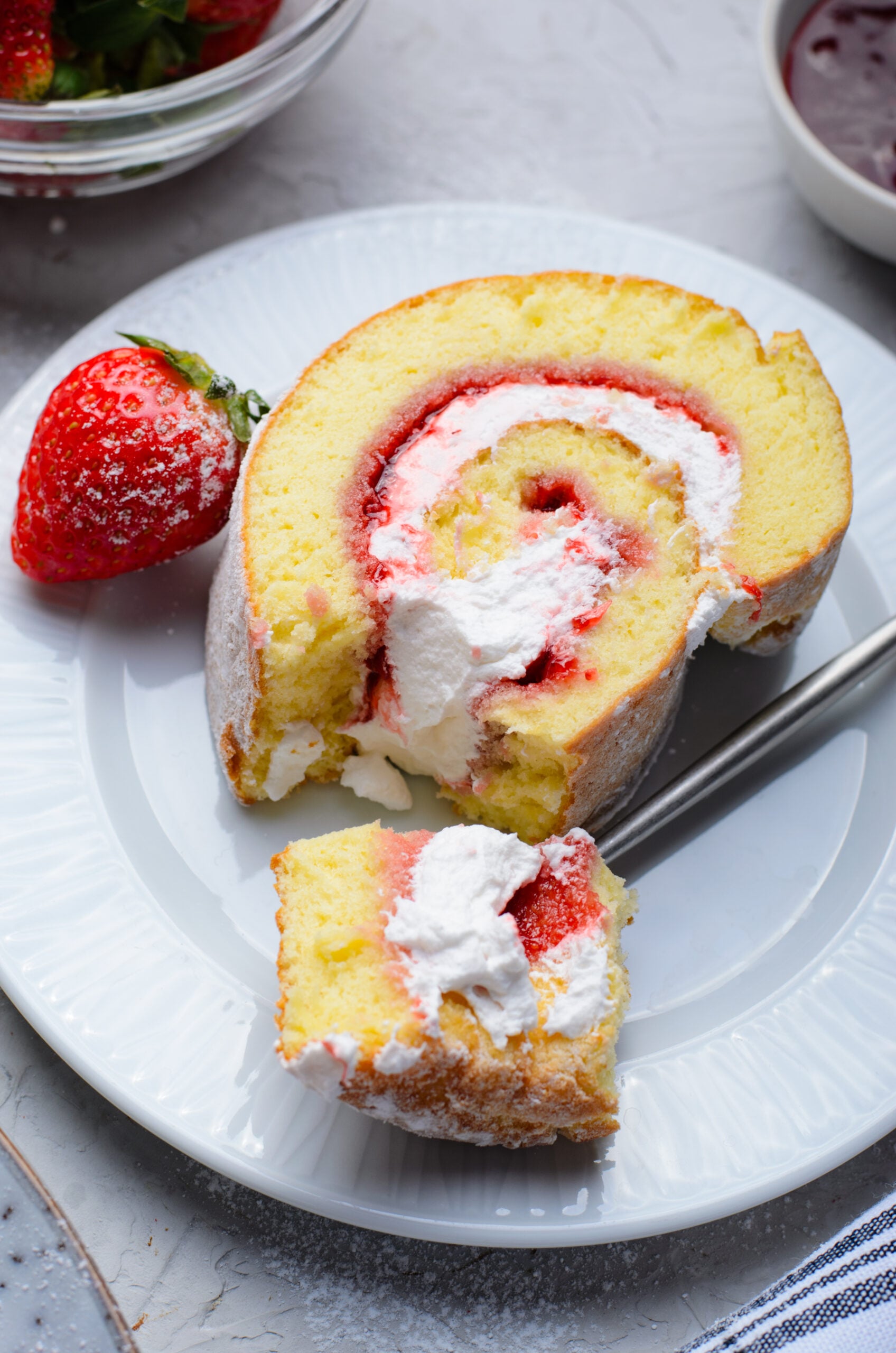 Overhead view of a slice of Strawberries & Cream Cake Roll with a bite removed