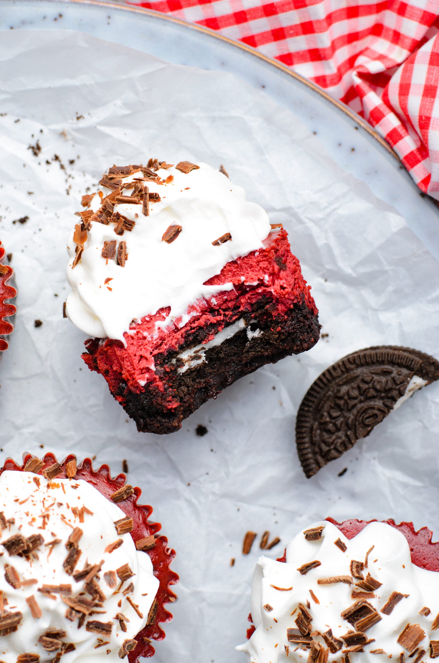 Overhead view of a Mini Red Velvet Oreo Cheesecake on its side with a bite removed.