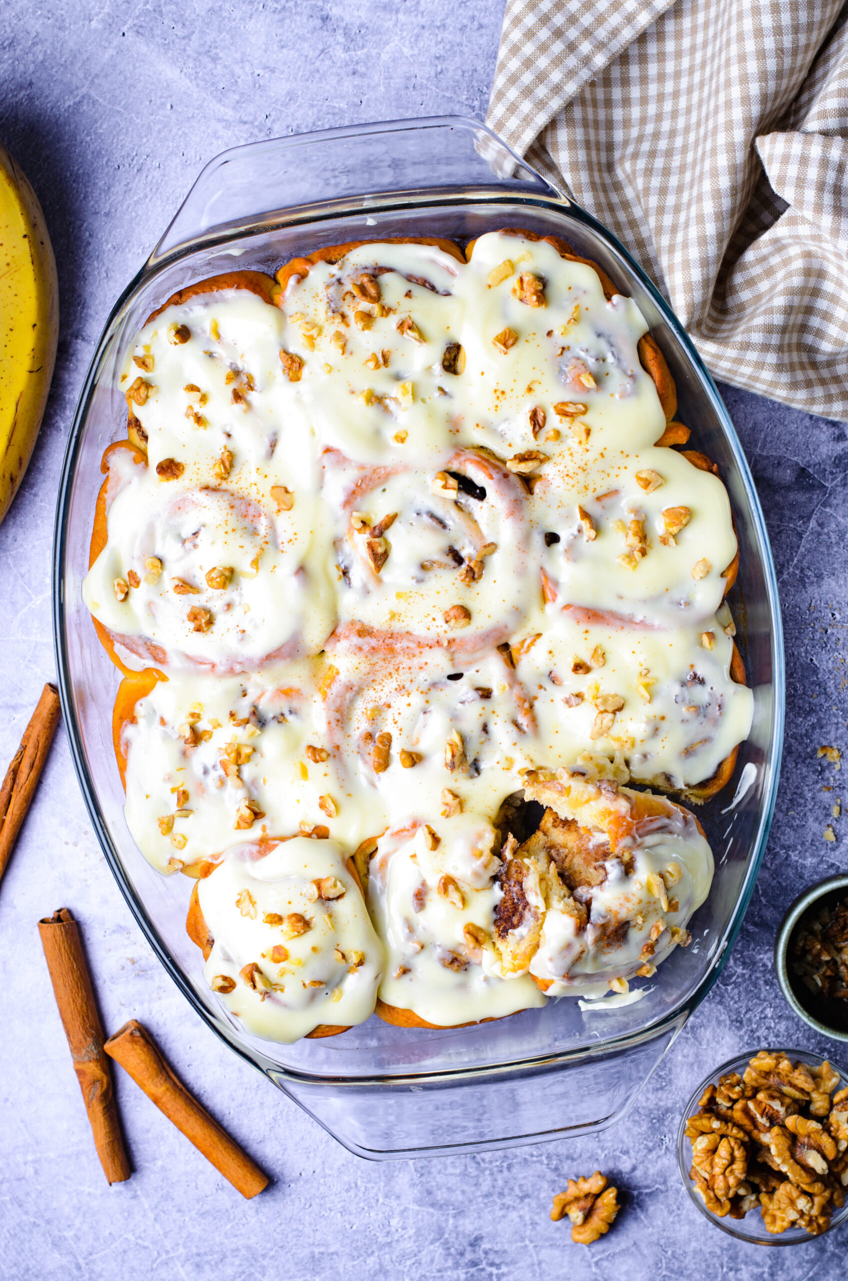 Overhead view of Banana Nut Cinnamon Rolls in a clear baking dish.