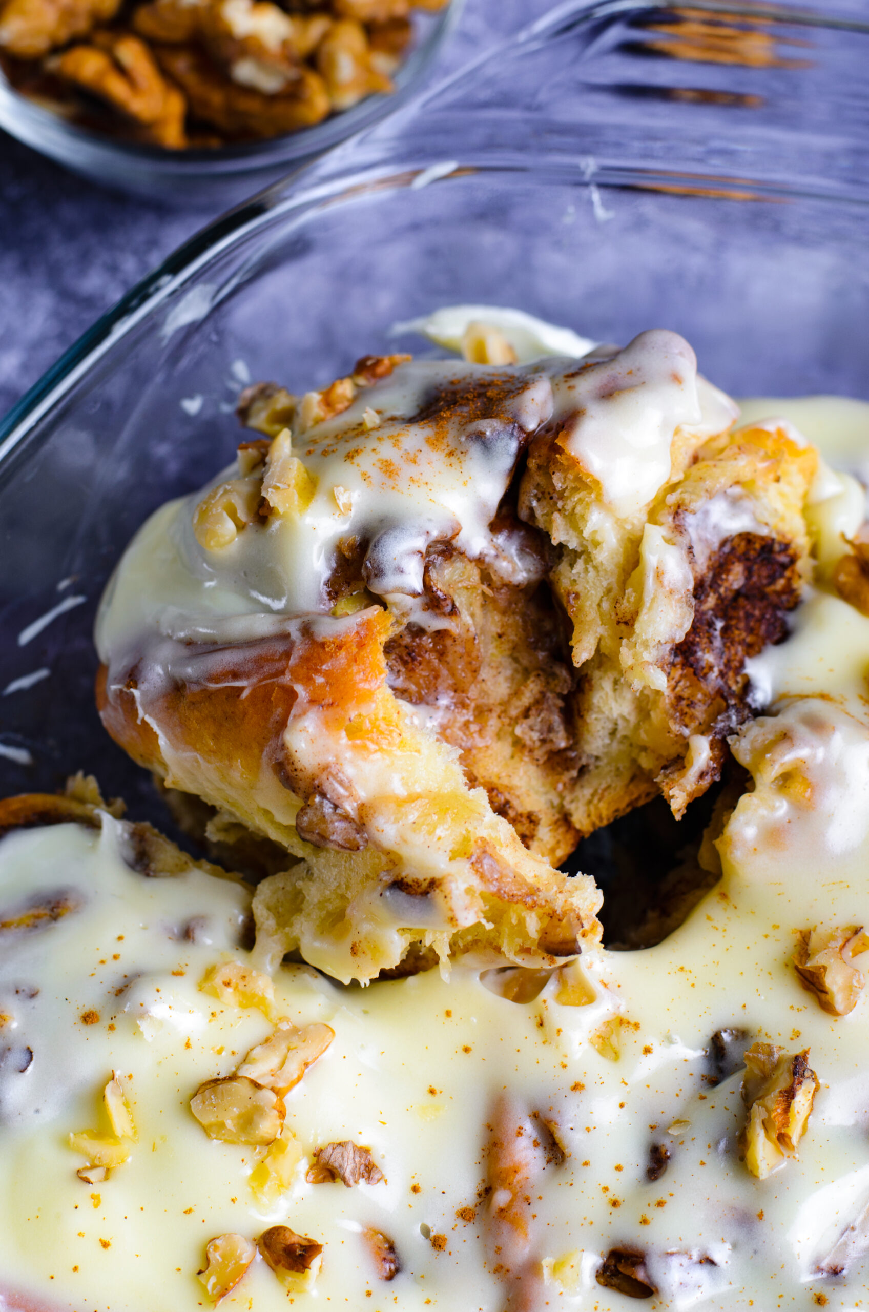 Close up view of a Banana Nut Cinnamon Roll in a clear baking dish.