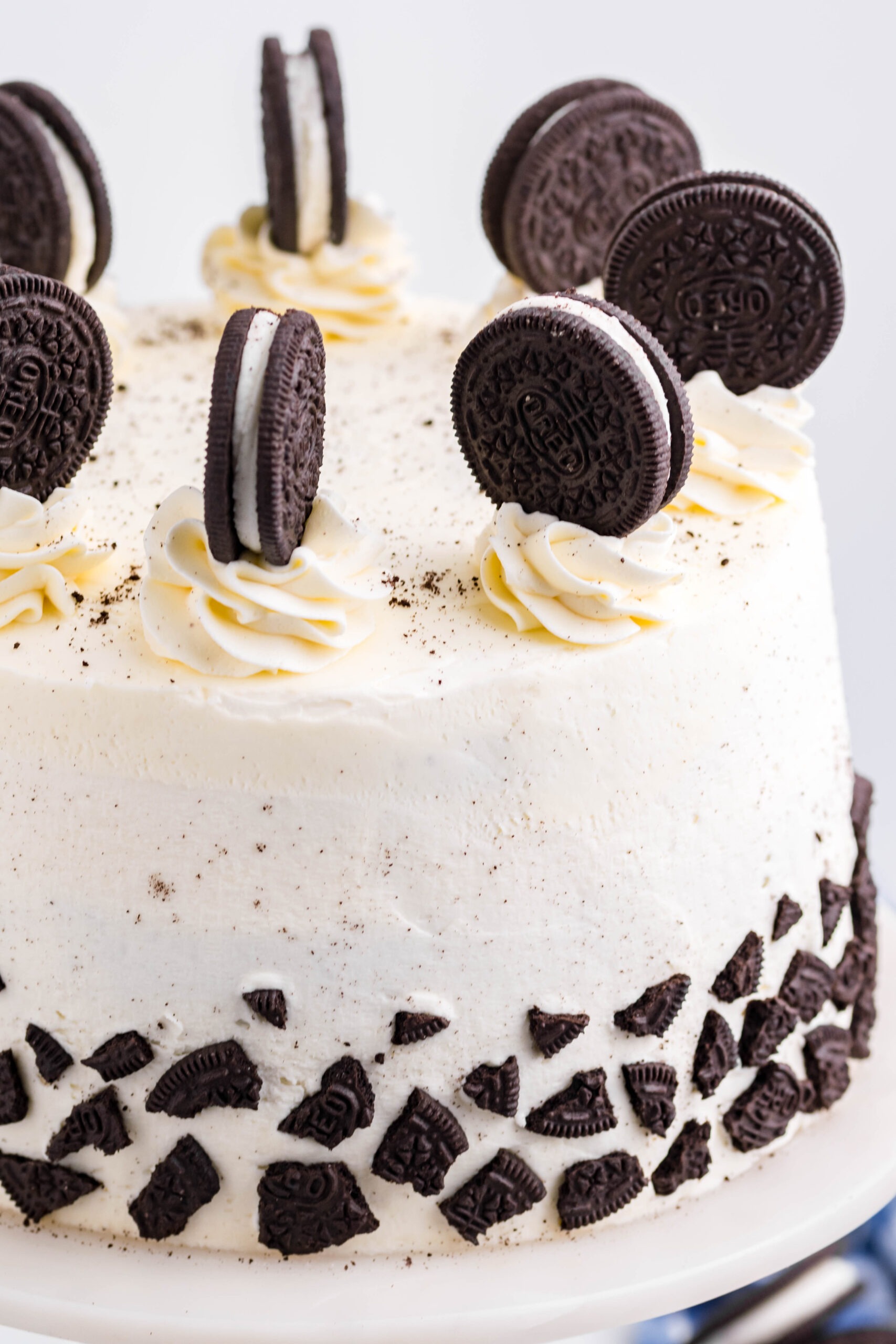 Close up view of Double Stuffed Oreo Cake on a white and wood cake stand.