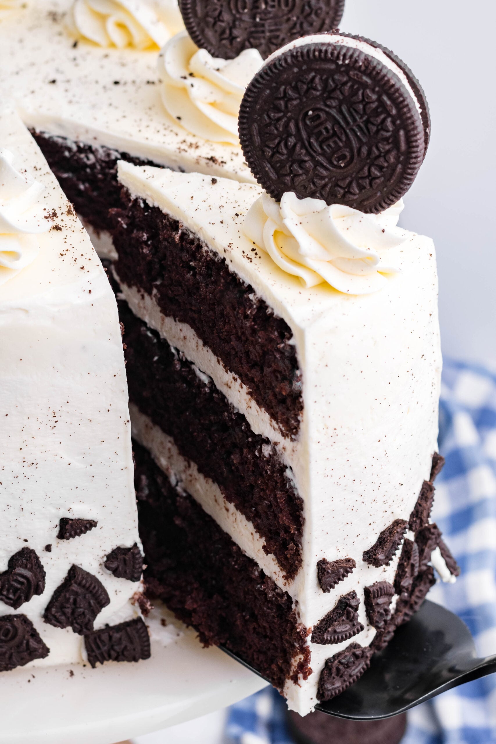 Close up view of a slice being removed from Double Stuffed Oreo Cake.