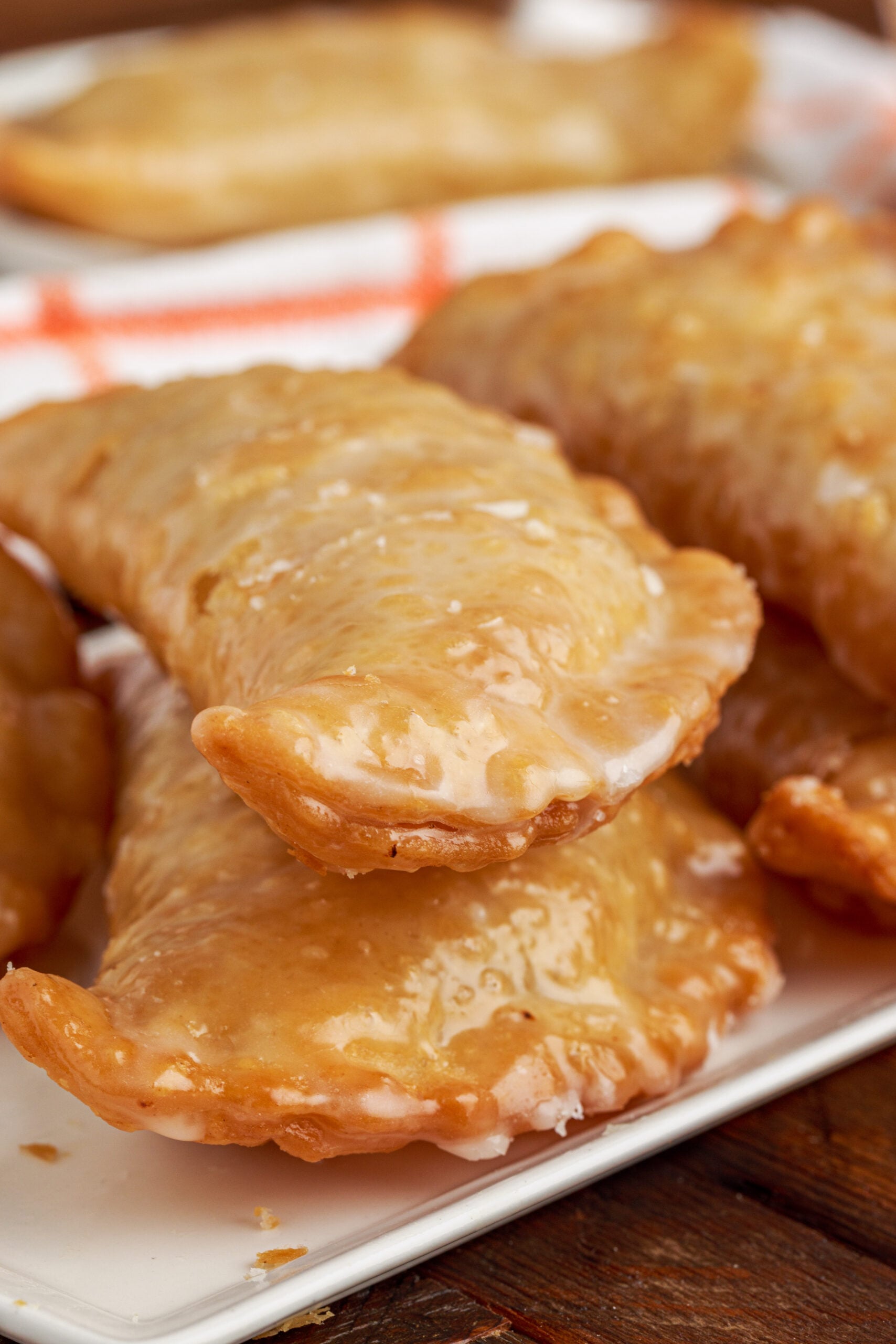 Up close view of two Peach Hand Pies stacked on a white serving dish.