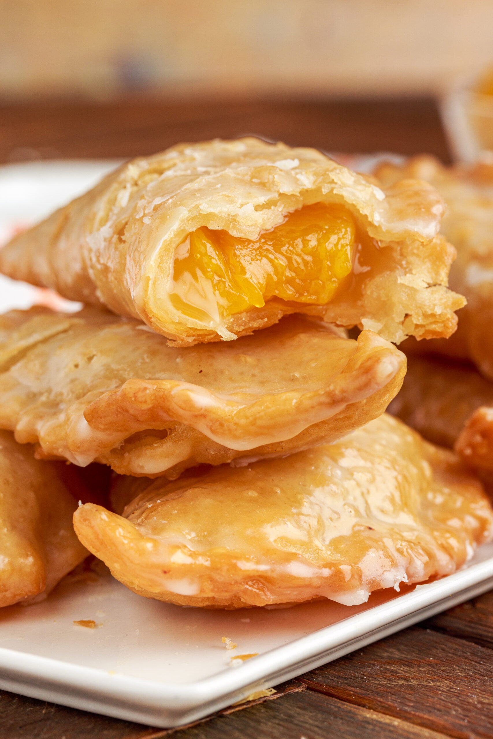 Up close view of three Peach Hand Pies stacked with a bite removed from the to pie.